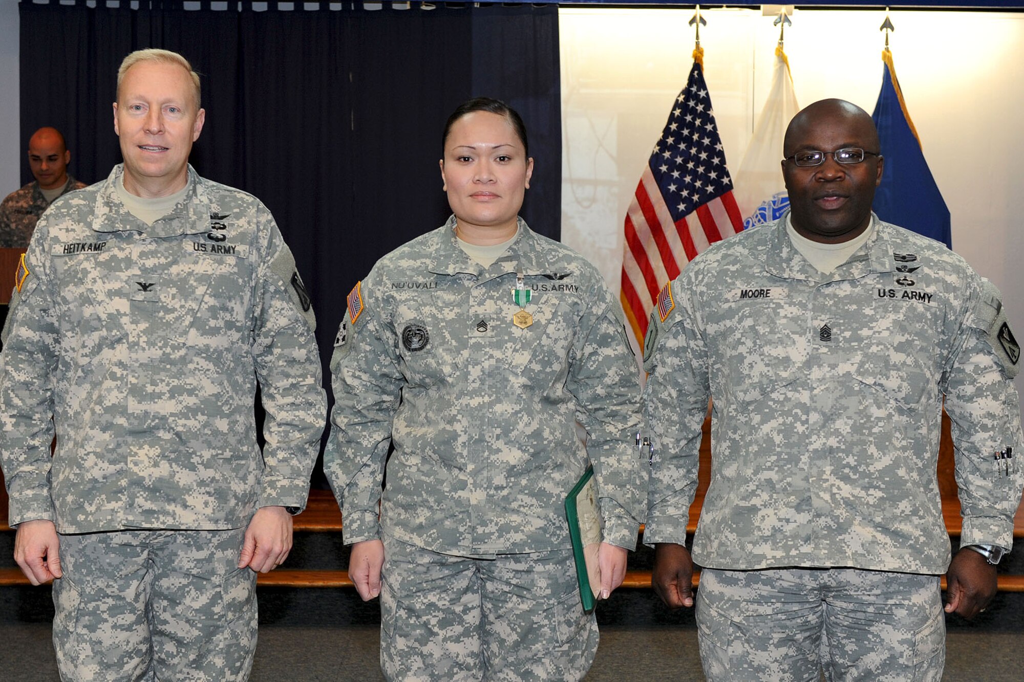 U.S. Army Col. Dean Heitkamp, 128th Aviation Brigade commander, and Command Sgt. Maj. John J. Moore flank Staff Sgt. Susie Nu’uvali, an instructor with C Company of the 2nd Battalion, 210th Aviation Brigade during an awards ceremony at Fort Eustis, Va., Feb. 1, 2013. Nu’uvali won the 2012 Noncommissioned Officer of the Year for her exceptional leadership abilities and outstanding performance on- and off-duty. (U.S. Air Force photo by Staff Sgt. Ashley Hawkins/Released)