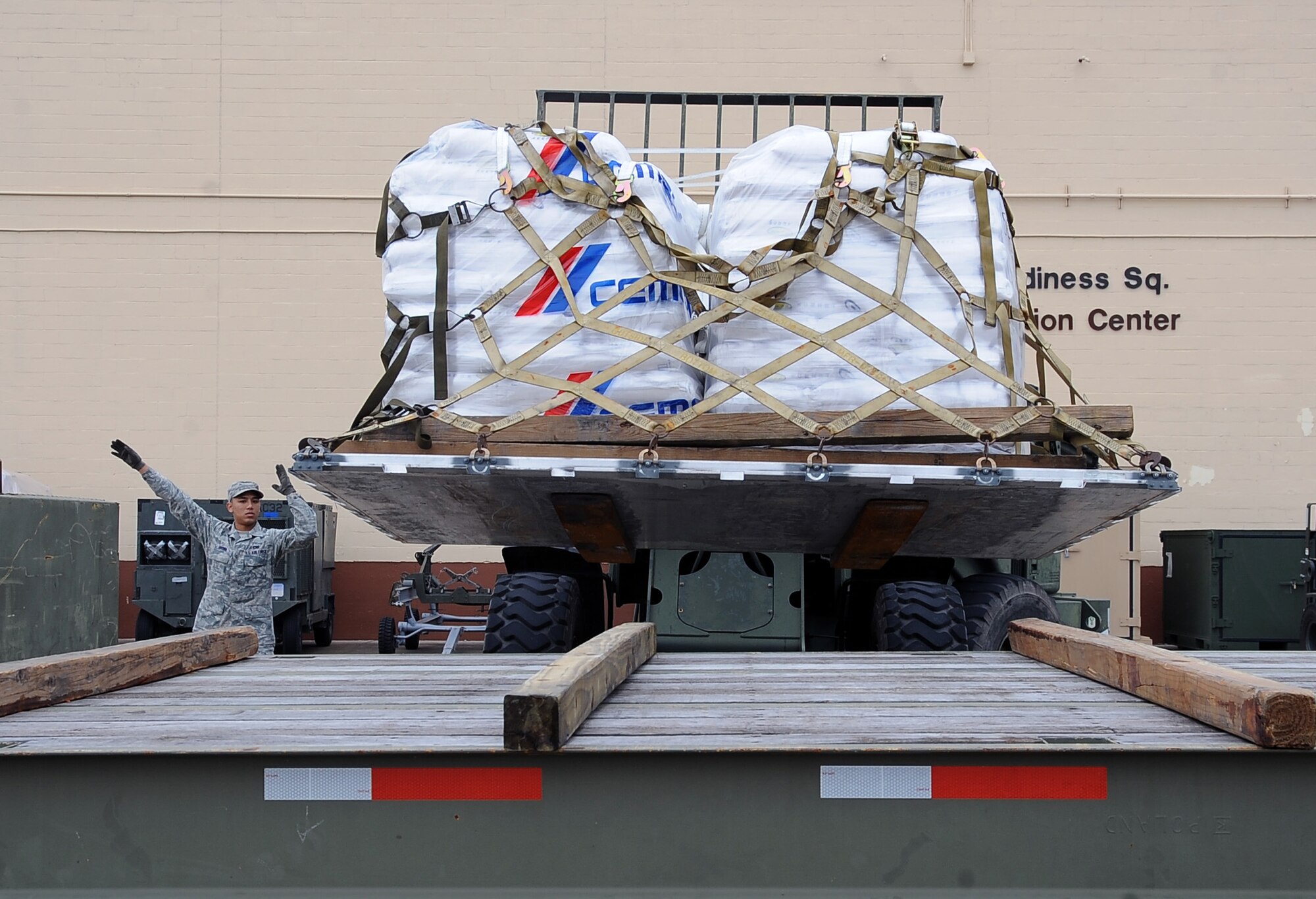 Senior Airman Pierre Brown, 2nd Logistics Readiness Squadron Vehicle Operations, directs Senior Airman Martin Hayes, 2 LRS vehicle ops, as he places an aircraft pallet on the back of a flatbed truck on Barksdale Air Force Base, La., Feb. 5. More than 42,000 pounds of rice was palletized by Airmen from the 2 LRS air terminal operations for transport from the base to Port au Prince, Haiti, in support of Children's Lifeline Foundation. (U.S. Air Force photo/Staff Sgt. Amber Ashcraft)