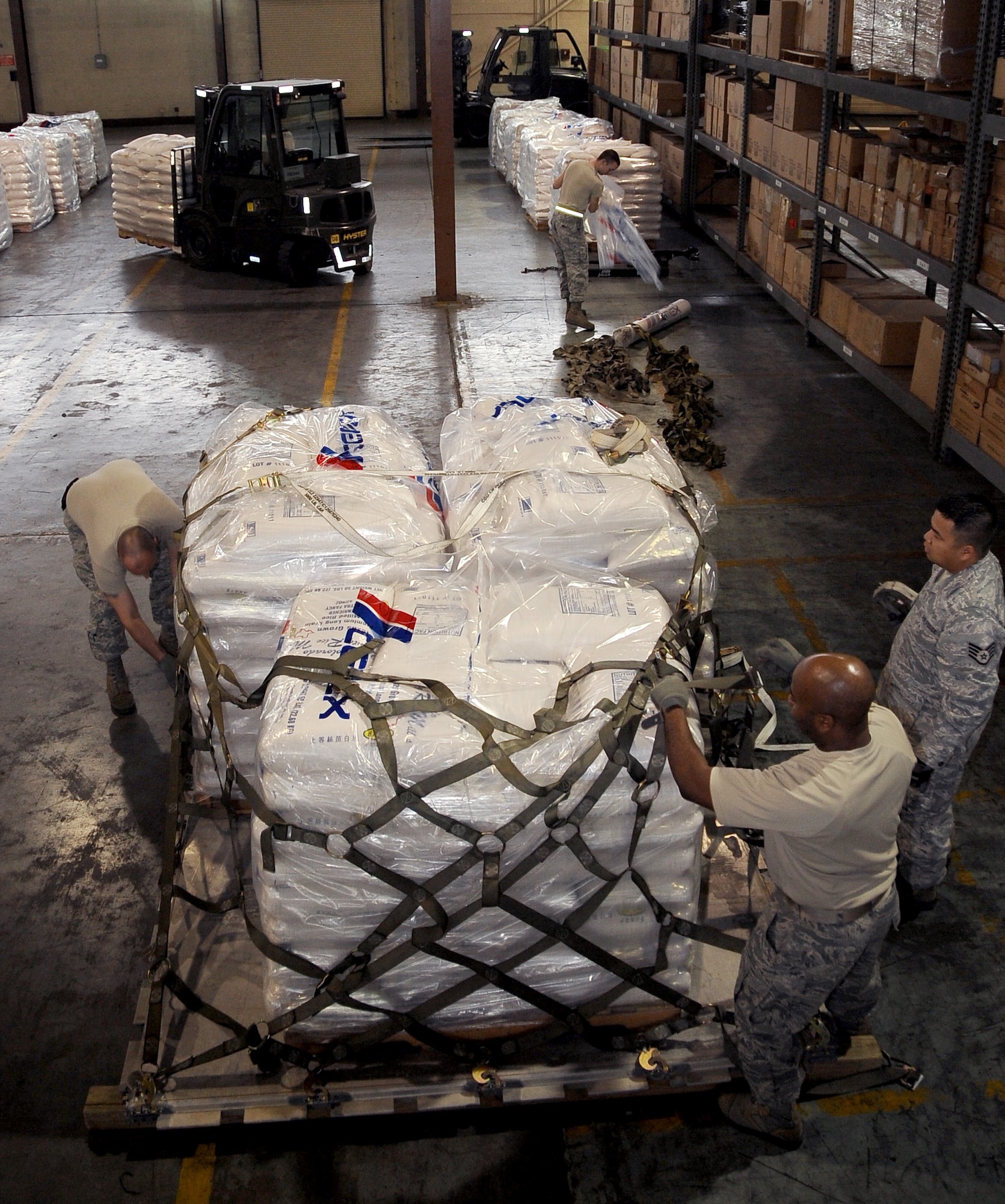 Airmen from the 2nd Logistics Readiness Squadron air terminal operations prepare an aircraft pallet to be transported on Barksdale Air Force Base, La., Feb. 5. ATO Airmen built several aircraft pallets of rice to be transported to Port au Prince, Haiti, in support of Children's Lifeline Foundation. The 42,000 pounds of rice will feed 8,500 children a day. (U.S. Air Force photo/Staff Sgt. Amber Ashcraft)