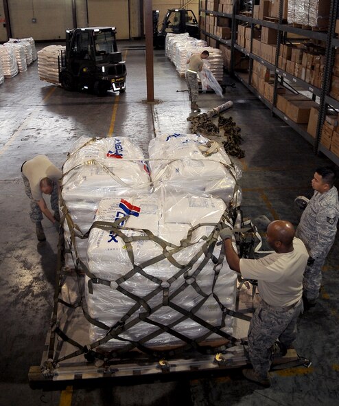 Airmen from the 2nd Logistics Readiness Squadron air terminal operations prepare an aircraft pallet to be transported on Barksdale Air Force Base, La., Feb. 5. ATO Airmen built several aircraft pallets of rice to be transported to Port au Prince, Haiti, in support of Children's Lifeline Foundation. The 42,000 pounds of rice will feed 8,500 children a day. (U.S. Air Force photo/Staff Sgt. Amber Ashcraft)