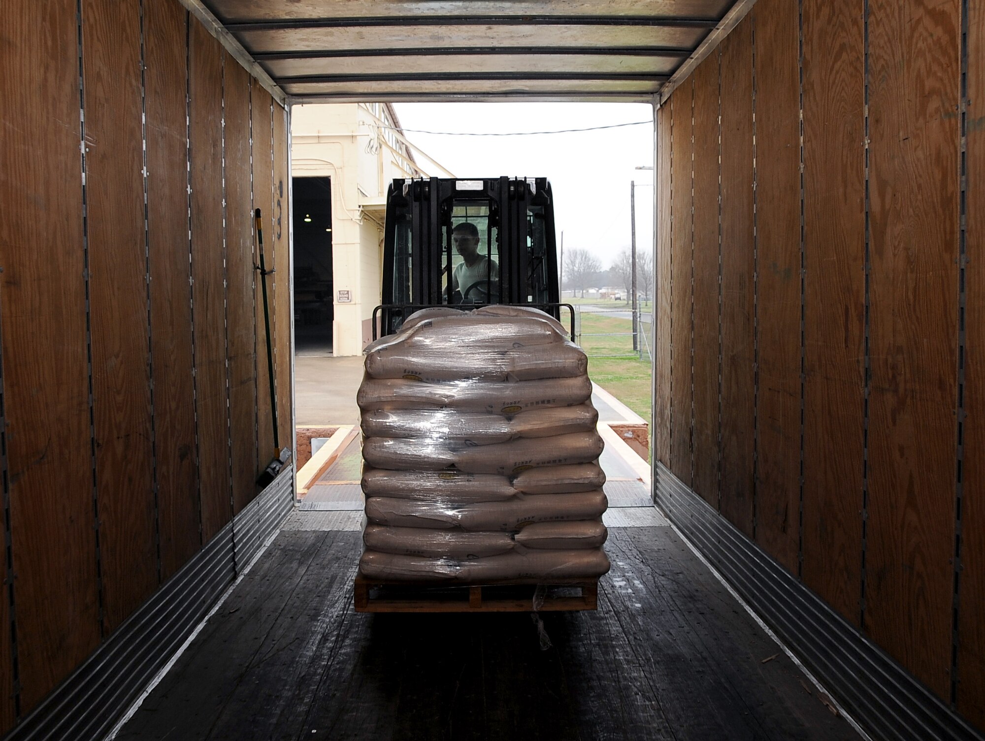 Staff Sgt. Bradley Stephens, 2nd Logistics Readiness Squadron air terminal operations, moves a skid of rice from a semi to a warehouse on Barksdale Air Force Base, La., Feb. 5. ATO Airmen packaged the skids on aircraft pallets to be flown to Port au Prince, Haiti. The rice will help feed more than 8,000 children a day. (U.S. Air Force photo/Staff Sgt. Amber Ashcraft)