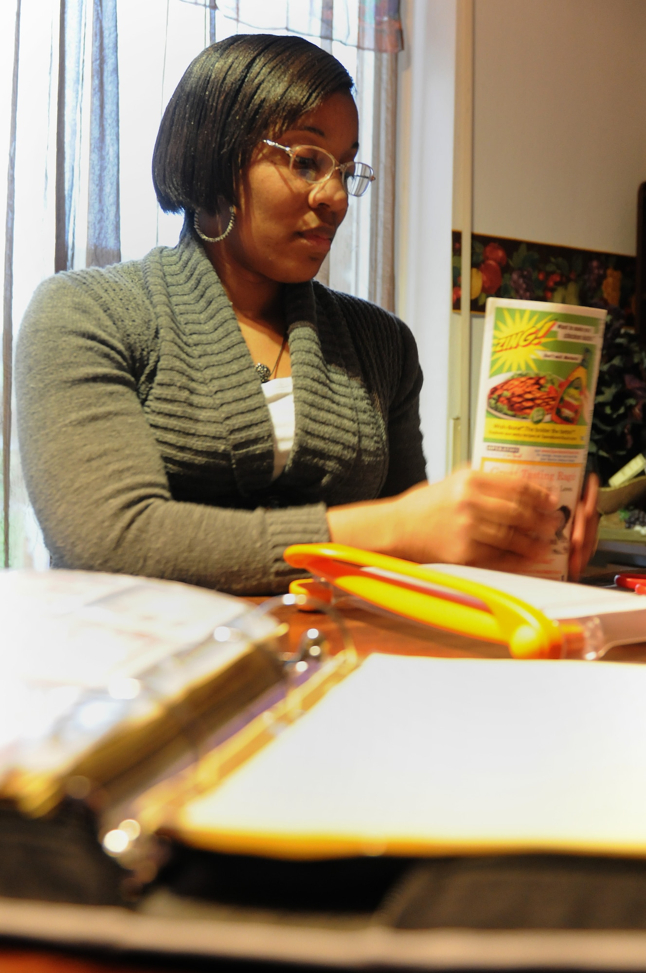 Tricia Beverly, wife of Army Staff Sgt. Wesley Beverly, 21st Theater Sustainment Command Headquarters material control and accountant supervisor, clips coupons at her home in Schwedelbach, Germany, Feb. 1, 2013. Beverly is a member of the couponing club for the Kaiserslautern Military Community, where she helps families learn how to save money by clipping coupons. (U.S. Air Force photo/Airman 1st Class Holly Cook)