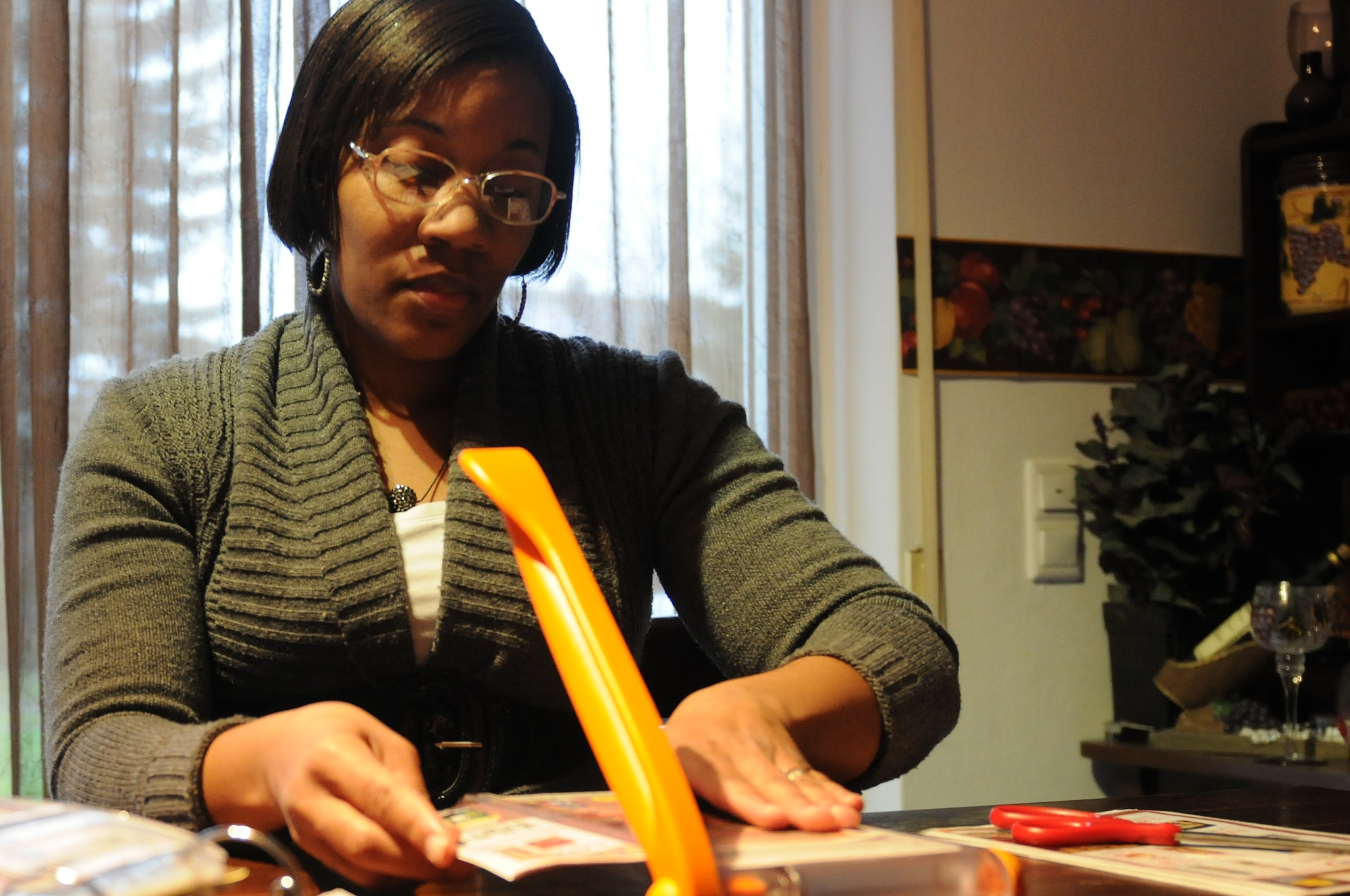 Tricia Beverly, wife of Army Staff Sgt. Wesley Beverly, 21st Theater Sustainment Command Headquarters material control and accountant supervisor, clips coupons at her home in Schwedelbach, Germany, Feb. 1, 2013. Beverly is a member of the couponing club for the Kaiserslautern Military Community, where she helps families learn how to save money by clipping coupons. (U.S. Air Force photo/Airman 1st Class Holly Cook)