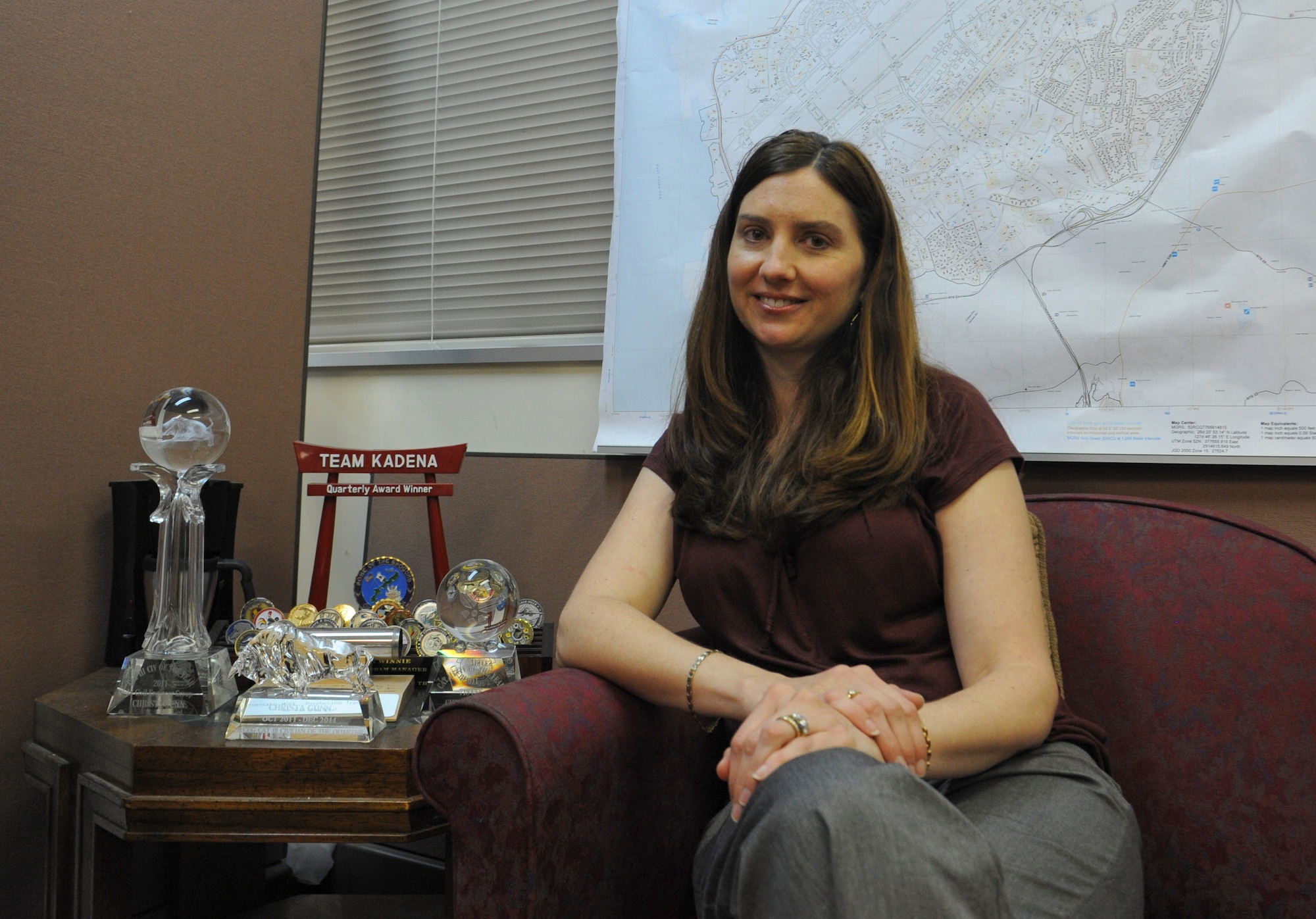 Christa Gunn, 718th Civil Engineer Squadron programs flight acting flight chief, sits next to her awards in her office on Kadena Air Base, Japan, Feb. 6, 2013. Gunn won the Outstanding Civil Engineer Manager of the Year Award at the Pacific Air Force and Air Force levels for her day-to-day accomplishments. (U.S. Air Force photo/Airman 1st Class Malia Jenkins) 