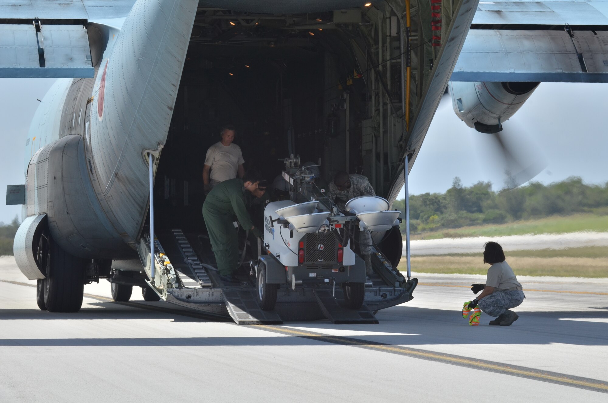 U.S. Air Force Airmen from the 36th Mobility Response Squadron and members of the Japan Air Self Defense Force unload flood lights out the back of a Japanese C-130 on the Tinian Airfield during exercise Cope North 2013 Feb. 5, 2013. Cope North is a multilateral aerial exercise, held once or twice yearly, designed to increase the combat readiness and interoperability of the U.S. Air Force, Japan Air Self-Defense Force, Royal Australian Air Force and other Pacific partner nations. (U.S. Air Force photo by Staff Sgt. Alex Montes/RELEASED)