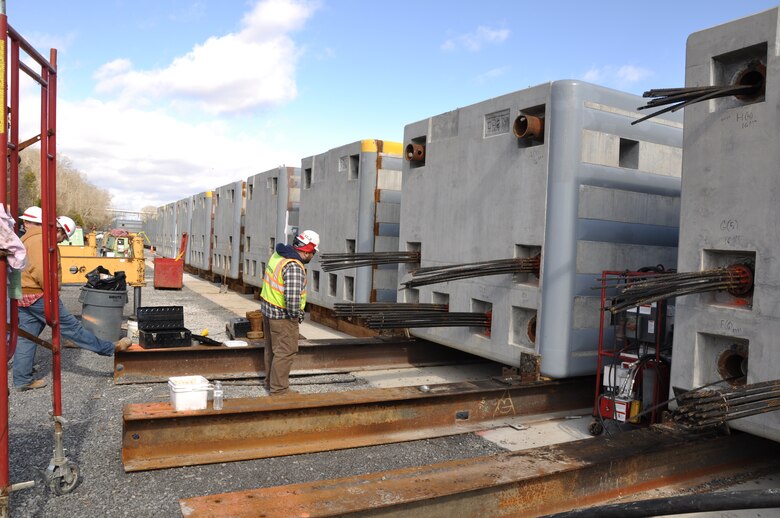 Mike Arles, quality assurance representative on the Chickamauga Lock Replacement Project checks steel cables that will be post-tensioned to 441-tons pressure connecting three sections of an approach wall beam at Watts Bar Dam, Decatur, Tenn., Jan. 31, 2013. The beams are being assembled and stored at Watts Bar for placement in the Chickamauga Lock Replacement Project when required for construction. (USACE photo by Fred Tucker)