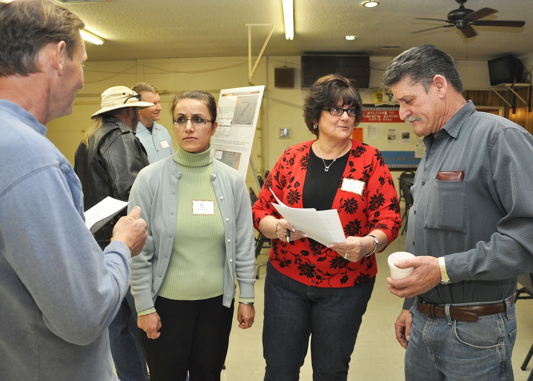 KINGMAN, Ariz. - At the public meeting the U.S. Army Corps of Engineers Los Angeles District held Feb. 5 regarding the upcoming Time Critical Removal Action at sites in the former Kingman Ground-to-Ground Gunnery Range Fran Firouzi (left), project manager, and Susan Hill, realty specialist, speak with Jim Dennis (right) and another member of the local community. Firouzi, Hill and other members of the USACE team were among the representatives from the Corps' project team available to the public to discuss the soil removal activities of hazardous material associated with the TCRA.