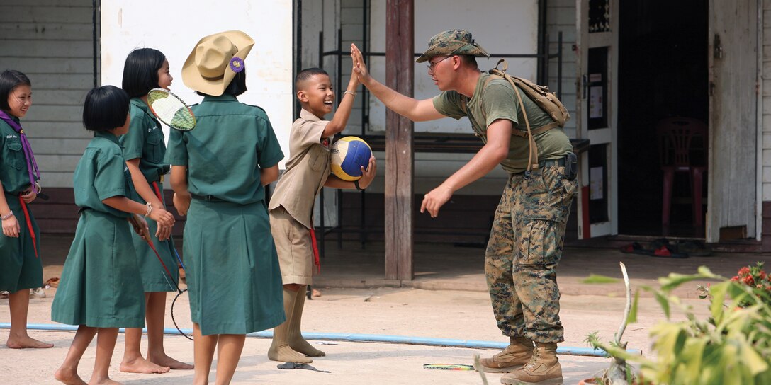 Niti Soonkoontod high-fives U.S. Marine Lance Cpl. Cuang V. Cao during their lunch break Jan. 24 at Chat Trakarn district, Phitsanulok province, Kingdom of Thailand. Cao is a combat engineer with 9th Engineer Support Battalion, 3rd Marine Logistics Group, III Marine Expeditionary Force.  Soonkoontod is a 12-year-old student of the Ban Kuad Nam Man School. 