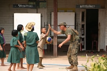 Niti Soonkoontod, left center, a 12-year-old student of the Ban Kuad Nam Man School, and U.S. Marine Lance Cpl. Cuong V. Cao high-five during their lunch break Jan. 24 at Chat Trakarn District, Phitsanulok province, Kingdom of Thailand. Royal Thai soldiers with 302nd Engineer Battalion, Royal Thai Army and U.S. Marines with 9th Engineer Support Battalion, 3rd Marine Logistics Group, III Marine Expeditionary Force, are constructing a new building as part of an ongoing engineering civic assistance project at the school part of exercise Cobra Gold 2013. Similar structures are being built at four other schools within two other provinces. Exercise Cobra Gold includes humanitarian and civic assistance projects, a staff exercise and field training exercises. Joint and multinational training is vital to maintaining the readiness and interoperability of all participating military forces. Cao is a combat engineer with 9th Engineer Support Battalion, 3rd Marine Logistics Group, III Marine Expeditionary Force.