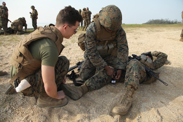 A Marine applies a tourniquet to a simulated casualty during 3rd Supply Battalion’s supply management unit exercise Jan. 25 at Kin Blue Training Area near Camp Hansen.
 