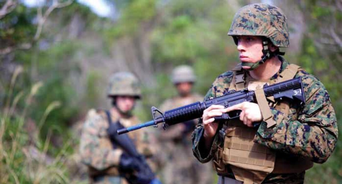 Cpl. James J. Amirault looks for simulated improvised explosive devices Jan. 29 at the Central Training Area near Camp Hansen during the III MHG-sponsored corporals course. Amirault is a student in the course and an engineer equipment electrical systems technician with 9th Engineer Support Battalion, 3rd Marine Logistics Group, III MEF.
