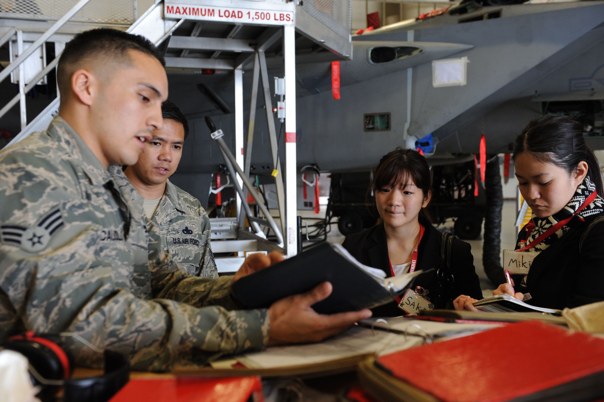 U.S. Air Force Senior Airman Nick Caudillo, 18th Equipment Maintenance Squadron crew chief, shows Saki and Miki, Nikkei College of Business students, a U.S. Air Force F-15 Eagle fighter jet during a tour of the 18th EMS during a five-day English conversation exchange program on Kadena Air Base, Japan, Jan. 31, 2013. The students participated in a five-day English conversation exchange program and toured different squadrons around base. (U.S. Air Force photo/Airman 1st Class Brooke P. Doyle)