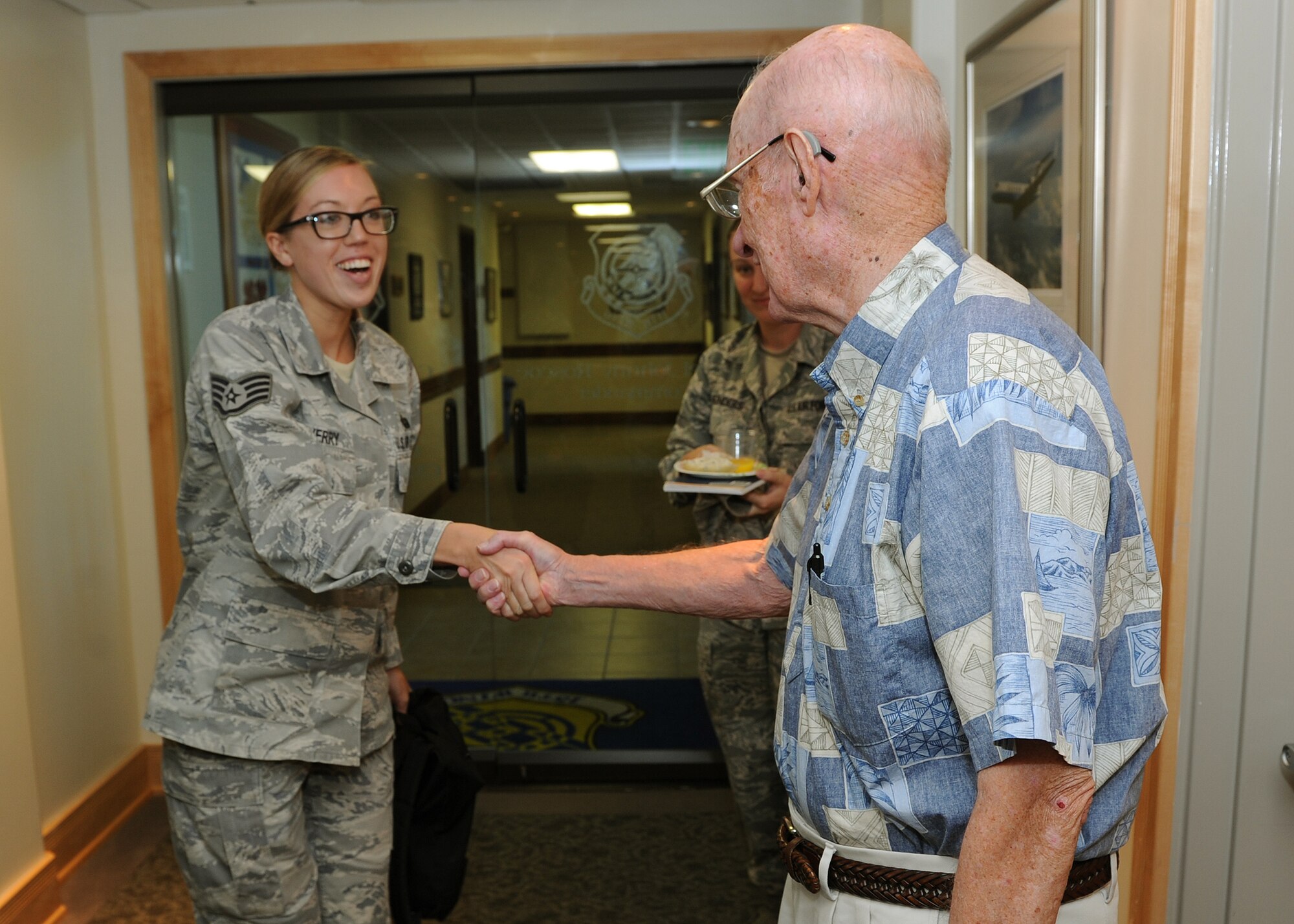 Staff Sgt. Tara Sherry, 15th Wing knowledge operations manager, shakes hands with retired Chief Master Sgt. of the Air Force James McCoy at the 15th Wing headquarters building, Joint Base Pearl Harbor-Hickam, Hawaii, Feb. 7, 2013. McCoy made a special visit to meet with 15th Wing leadership and Airmen during a brief office call. McCoy served as the sixth chief master sergeant of the Air Force from 1979-1981. (U.S. Air Force photo/Tech. Sgt. Jerome S. Tayborn)