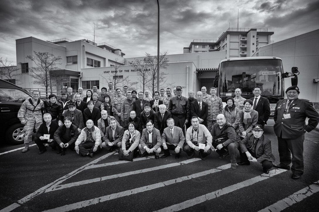 YOKOTA AIR BASE, Japan -- The Saitama Prefecture Defense Association poses for a group photo with the Band of the Pacific-Asia musicians after receiving a tour of the facility and a short performance from Pacific Showcase, jazz ensemble, at Yokota Air Base, Japan, Feb. 5, 2013. Visitors from the surrounding communities often visit the band to experience a live performance and learn more about the band's mission capabilities. (U.S. Air Force photo by Staff Sgt. Josh Voyles)