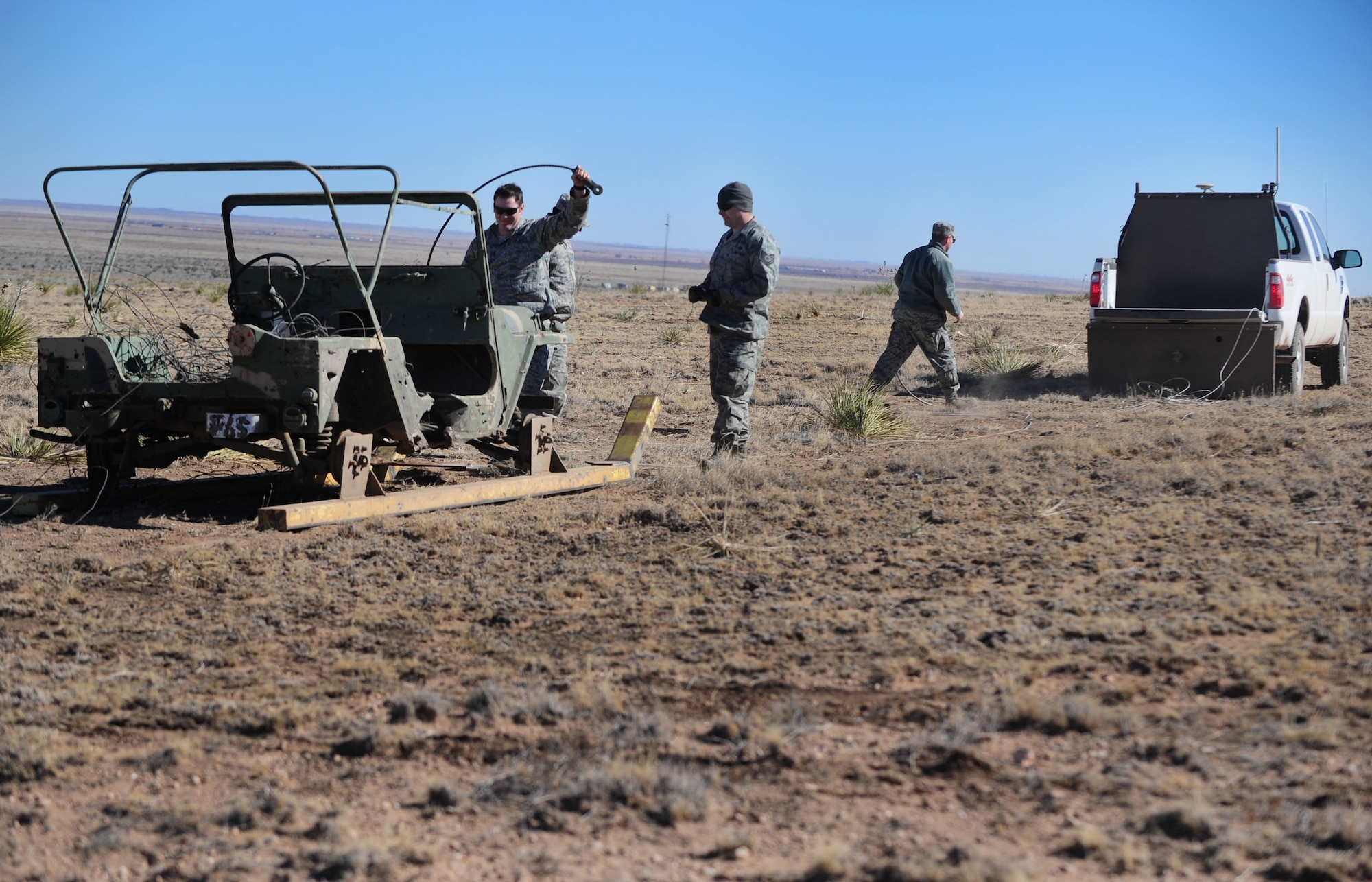 The explosive ordnance device ground crew attach a target to an unmanned vehicle at Melrose Air Force Range, N.M., Feb. 4, 2013. The unmanned vehicle is a new piece of equipment recently acquired by Cannon Air Force Base, N.M. Its remote-control capabilities allow the squadrons to practice shooting at a moving target without putting any human life in danger. (U.S. Air Force photo/Airman 1st Class Ericka Engblom)