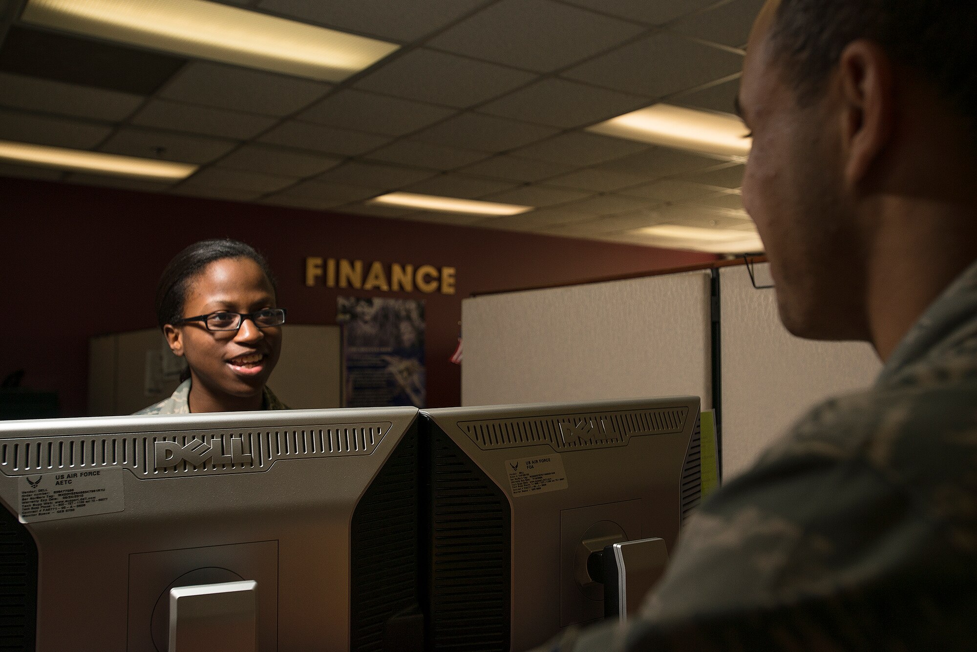Airman 1st Class Mimi Greasham, a 19th Comptroller Squadron financial technician, assists Airman 1st Class Carlos Thompson, a 19th Logistic Readiness Squadron air transportation journeyman, with his military pay Jan. 31, at Little Rock Air Force Base. Greasham said one of the hardest parts about working in finance is the sometimes late hours. (U.S. Air Force photo by Airman 1st Class Regina Agoha) 