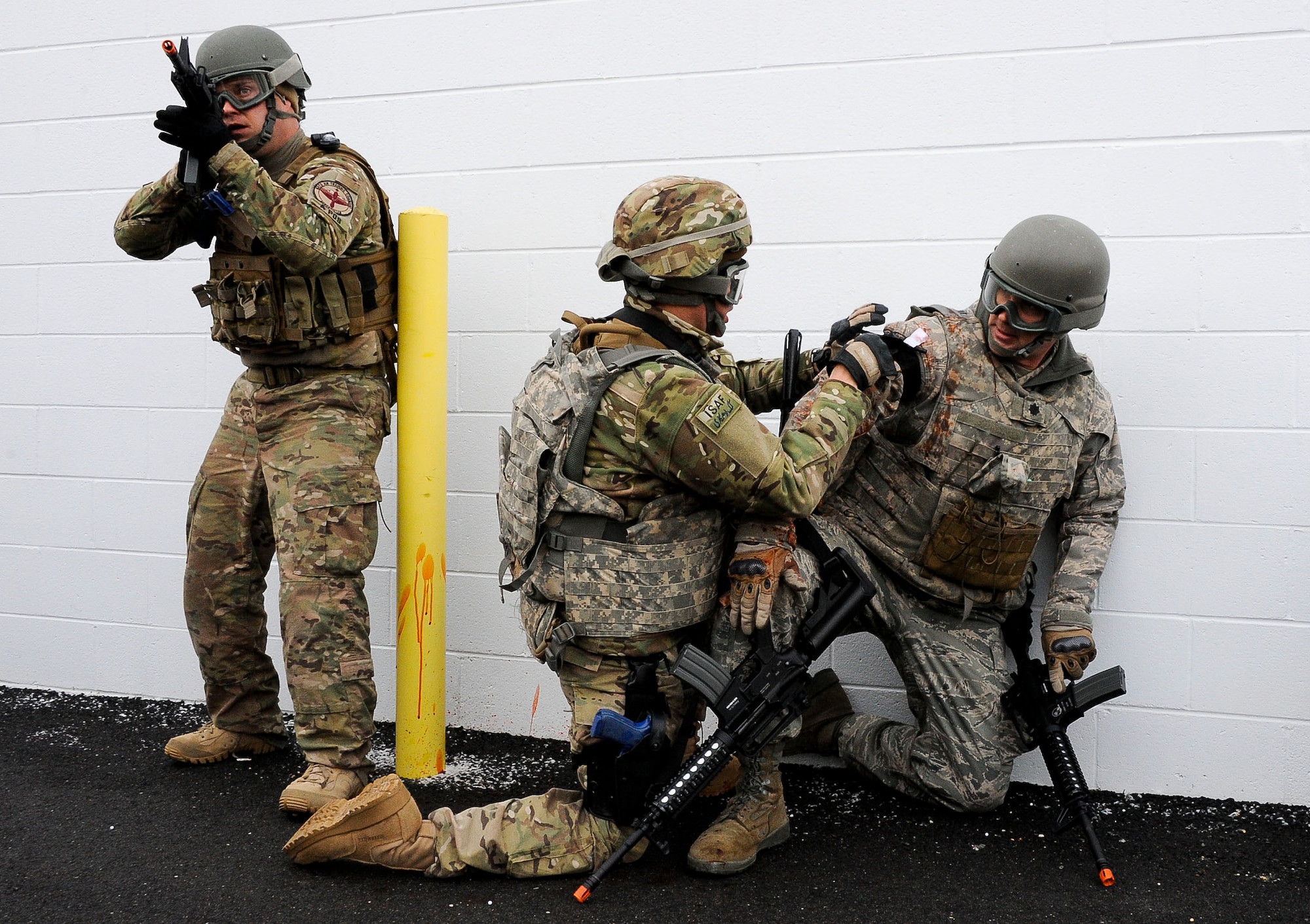 An Air Advisor Academy student applies a combat dressing to a wingman’s simulated wound Feb. 1, 2013, on the ranges at Joint Base McGuire-Dix-Lakehurst, N.J., as part of their field training exercise. Mock casualties added stress and urgency to the scenario, while also giving students a chance to put their training to the test. (U.S. Air Force photo by Airman 1st Class Ryan Throneberry/Released)