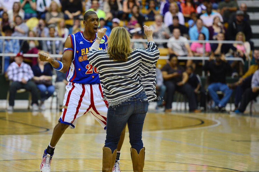 Hi-Lite Bruton, forward for the Harlem Globetrotters, dances with the spouse of U.S. Air Force Lt. Col. Chester Dooly, 73rd Special Operations Squadron director of operations, during an intermission of a basketball game at the Greyhound Arena in Portales, N.M., Feb. 5, 2013. The Harlem Globetrotters offered a crowd of several hundred people a comical, energy-packed game.(U.S. Air Force photo/Airman 1st Class Eboni Reece)