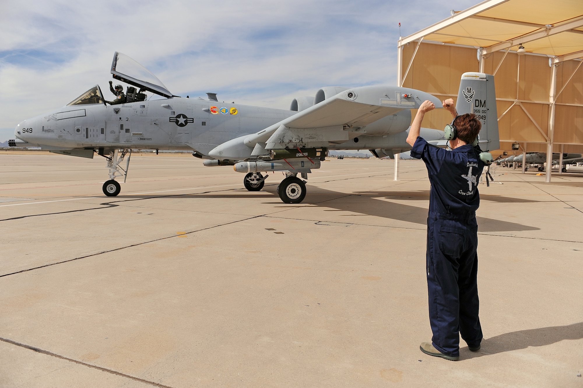 U.S. Air Force Chief Master Sgt. Dawna Cnota, 355th Fighter Wing command chief master sergeant, cheers on Col. James Meger, 355th Fighter Wing vice commander, as he prepares for take-off on the flightline on Davis-Monthan Air Force Base, Ariz. Feb. 4, 2013. Chief Cnota launched out Colonel Meger to get the experience of what it's like to be a U.S. Air Force crew chief.  (U.S. Air Force photo by Airman 1st Class Christine Griffiths/Released)