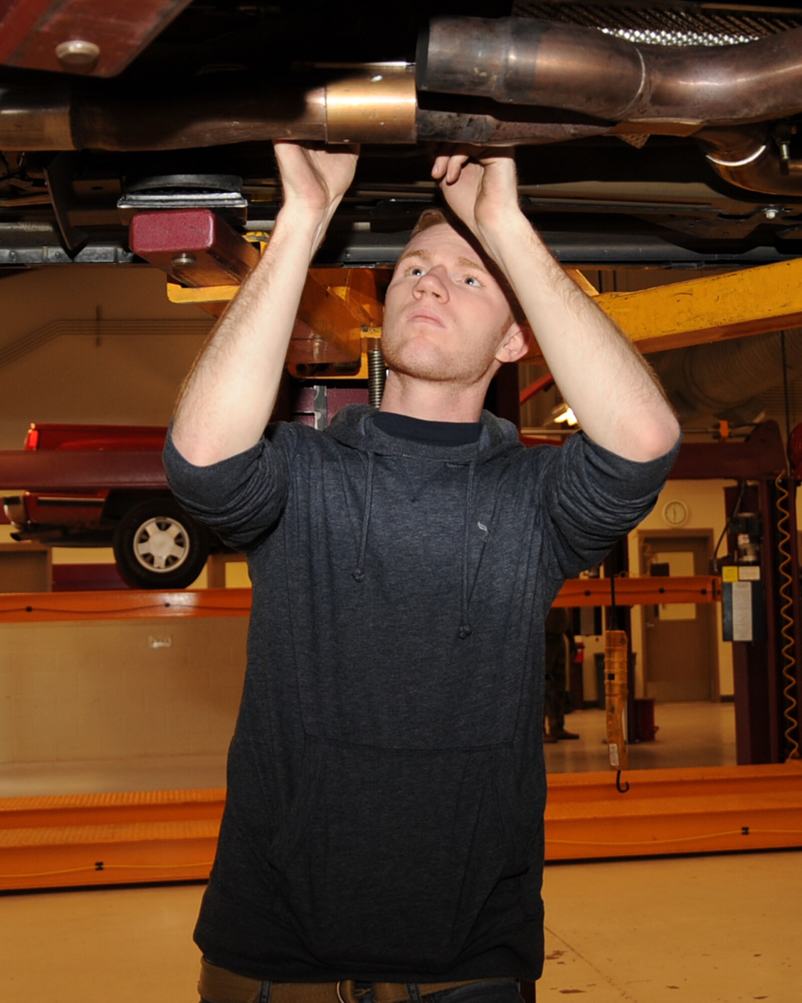 Senior Airman John Aubuchon, 2nd Aircraft Maintenance Squadron communication navigation journeyman, attaches a catback exhaust to his car at the Auto Hobby Shop on Barksdale Air Force Base, La., Feb. 7. The shop gives base personnel a place to work on their vehicles providing all the essentials tools.  (U.S. Air Force photo/Senior Airman Sean Martin)