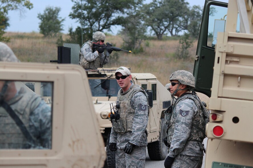 Tech. Sgt. Stephen Mooney and Staff Sgt. Ernest Perez (right), Combat Airman Skills Training instructors, look on as students from a CAST class conduct a cross flow of simulated injured personnel from one vehicle to another, Nov. 12, 2012 at Camp Anderson-Peters, Texas. Instruction of cross flow between vehicles is just one of the many courses offered at CAST training. (U.S. Air Force photo/Tech. Sgt. Jason Wells)