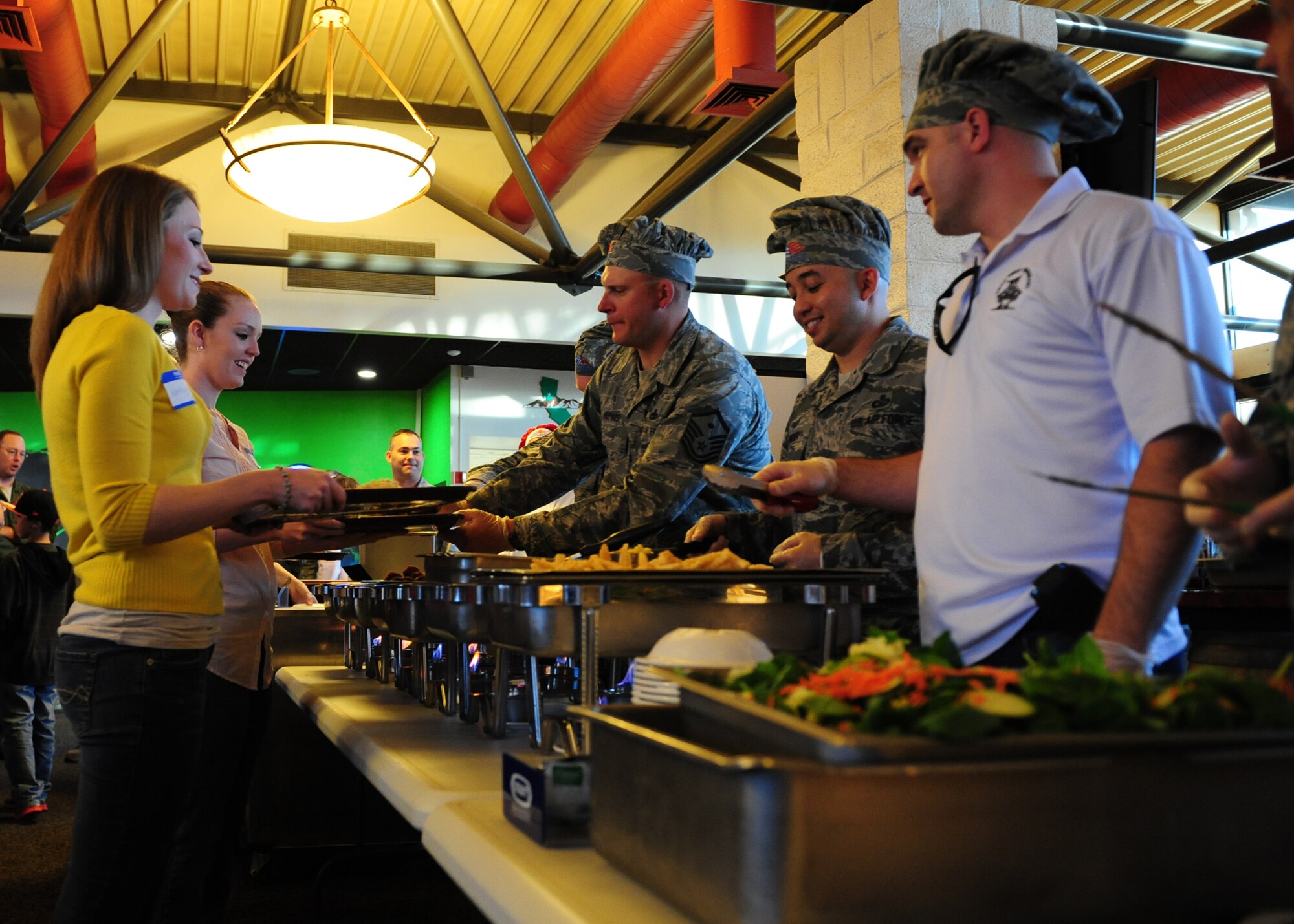 Beale first sergeants serve food to families of deployed Airmen during a Valentine's Day themed Hearts Apart Dinner at the Contrails Inn Feb. 6. The Airmen & Family Readiness Center together with Beale’s first sergeants hosted the dinner for families to get together for a night of food, fun and prizes. (U.S. Air Force photo by Senior Airman Shawn Nickel/Released)