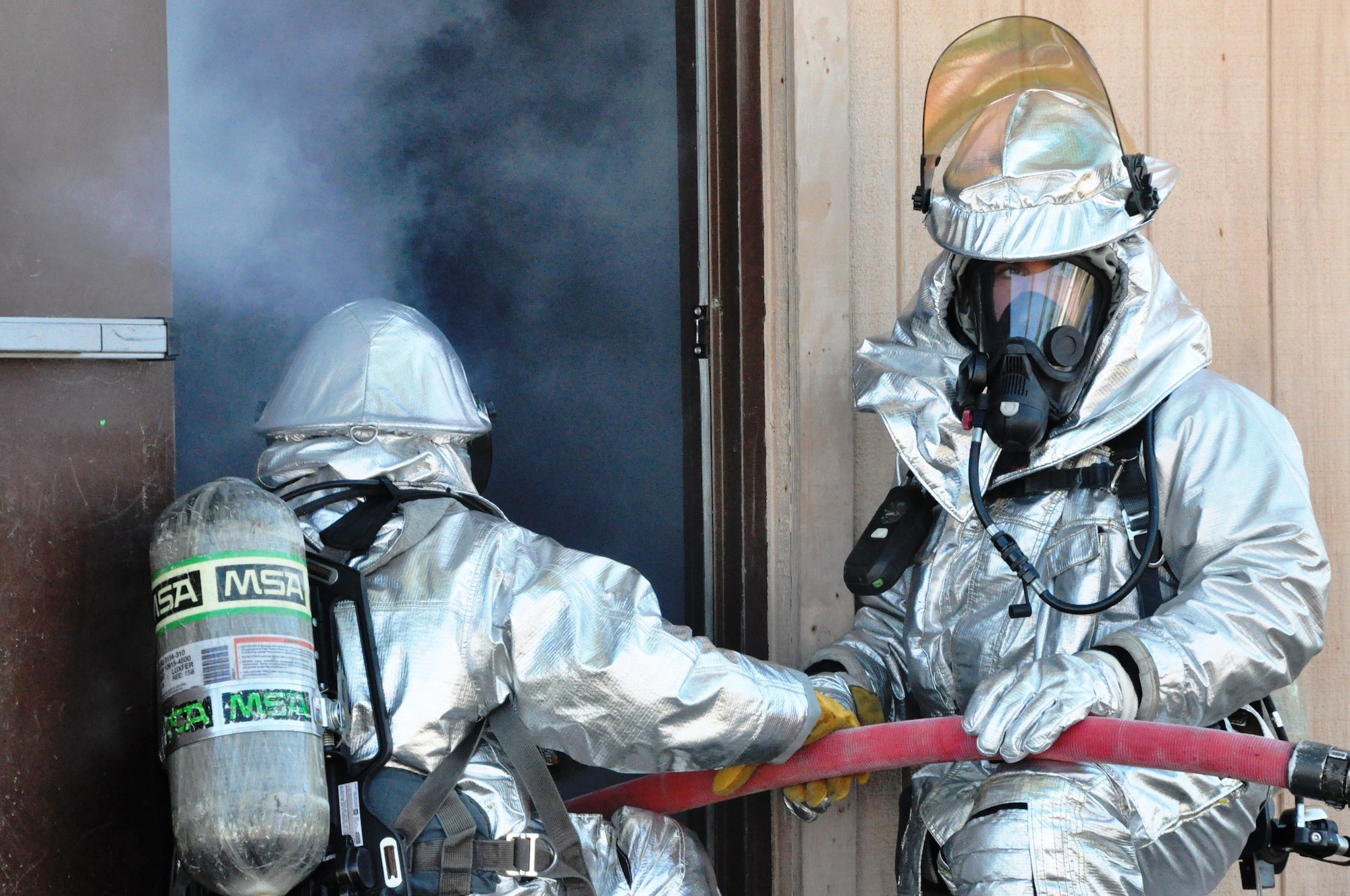Firefighters participating in the 823rd RED HORSE Squadron Silver Flag fire training prepare to enter a simulated residential house fire. (U.S. Air Force photo by Staff Sgt. Rachelle Elsea)
