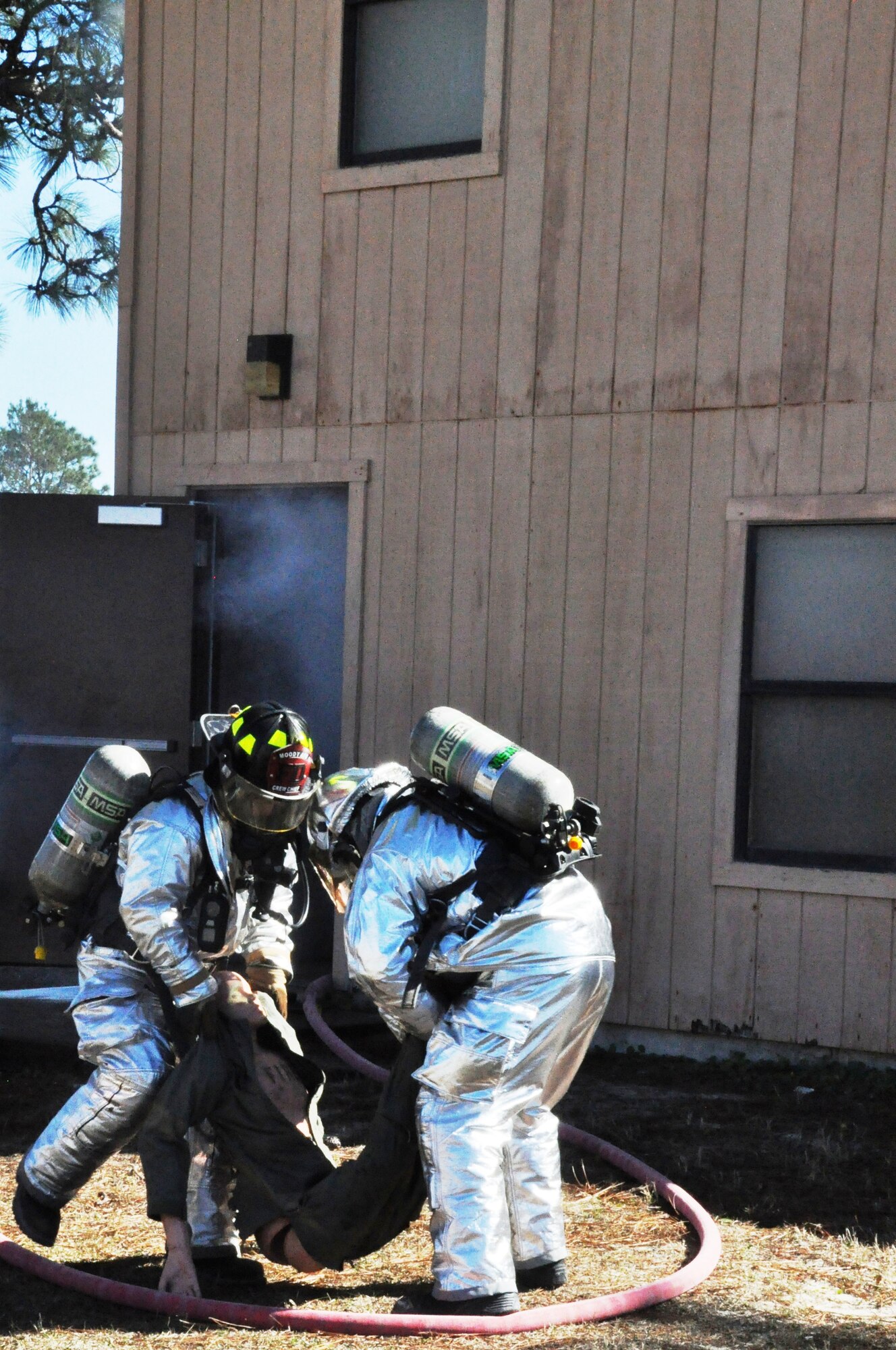 Firefighters participating in the 823rd RED HORSE Squadron Silver Flag fire training rescue a dummy during a simulated residential house fire. (U.S. Air Force photo by Staff Sgt. Rachelle Elsea)