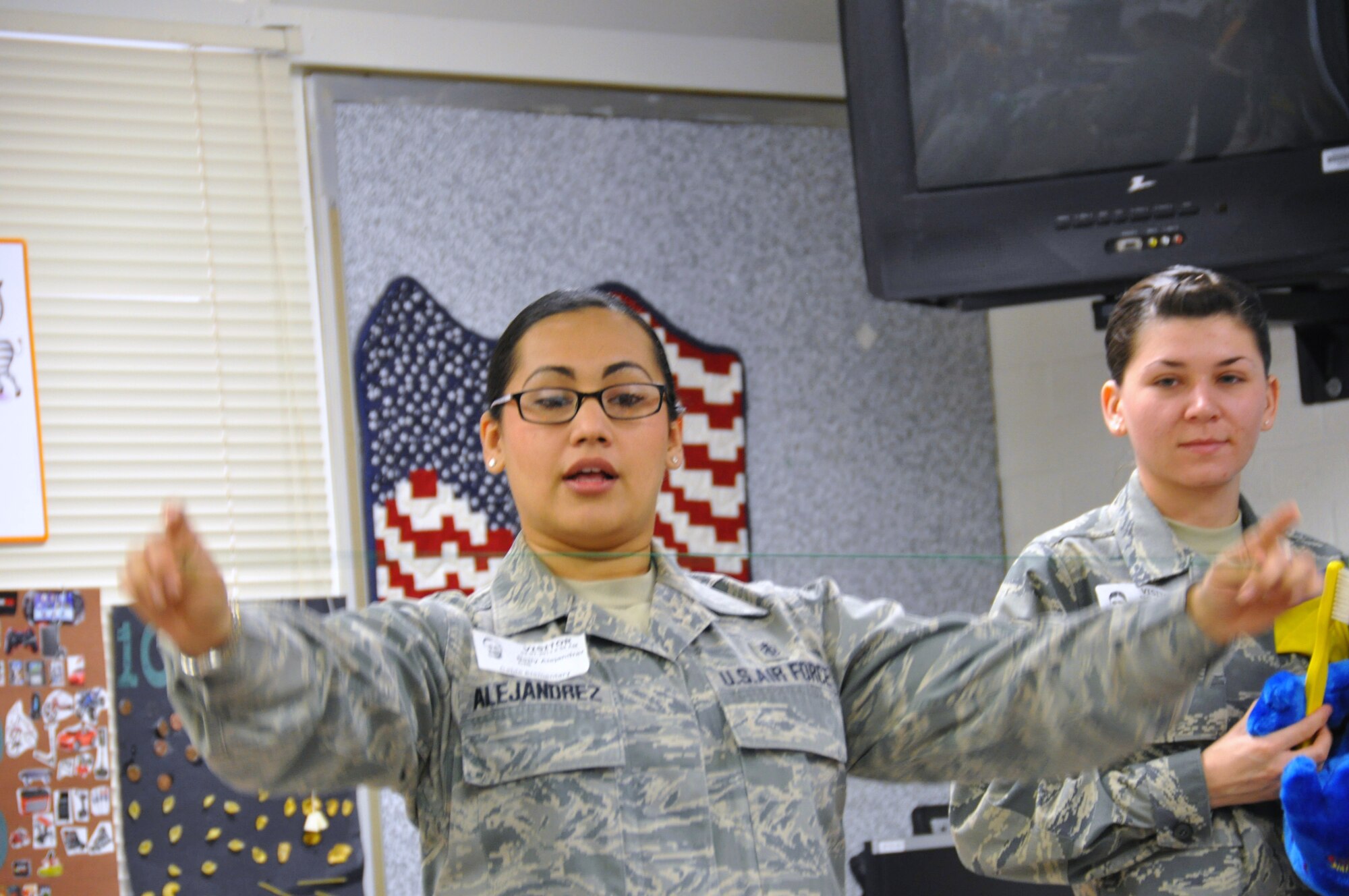 Tech. Sgt. Betty Alejandrez and Staff Sgt. Ashley Kilby, 433rd Aerospace Medicine Squadron dental assistants, demonstrate how to properly use dental floss during a visit to Cable Elementary in San Antonio, Texas on Feb. 7, 2013. (U.S. Air Force Photo/Tech Sgt. Carlos J. Trevino)