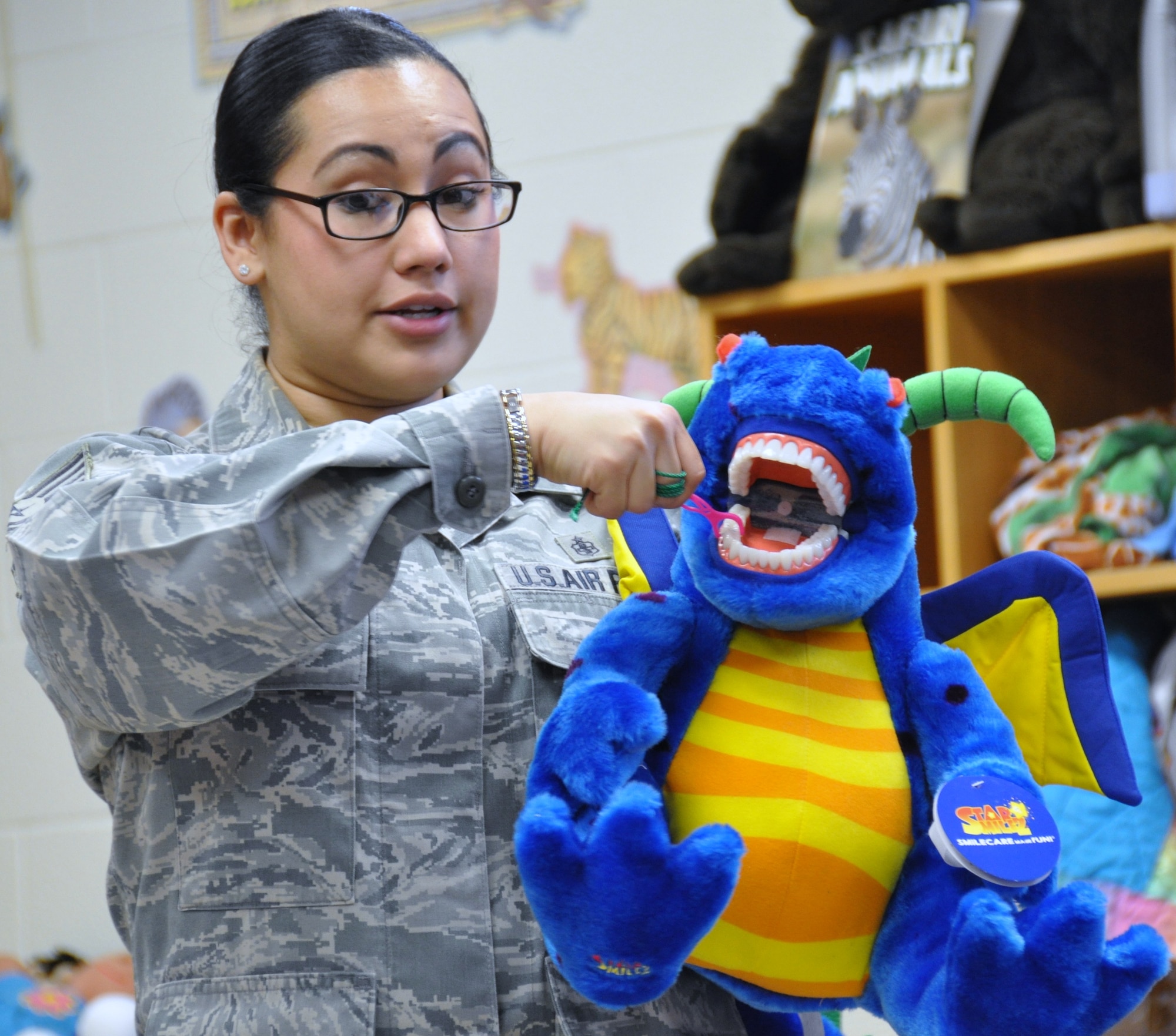 Tech. Sgt. Betty Alejandrez, a 433rd Aerospace Medicine Squadron dental assistant, demonstrates how to brush your teeth using Ralph the Dental Dragon during a visit to Cable Elementary in San Antonio, Texas on Feb. 7, 2013.  Airmen from the 433rd AMDS gave presentations on how to maintain good oral hygienne through brushing, flossing and healthy snack choices to over 120 kindergarteners. (U.S. Air Force Photo/Tech Sgt. Carlos J. Trevino)