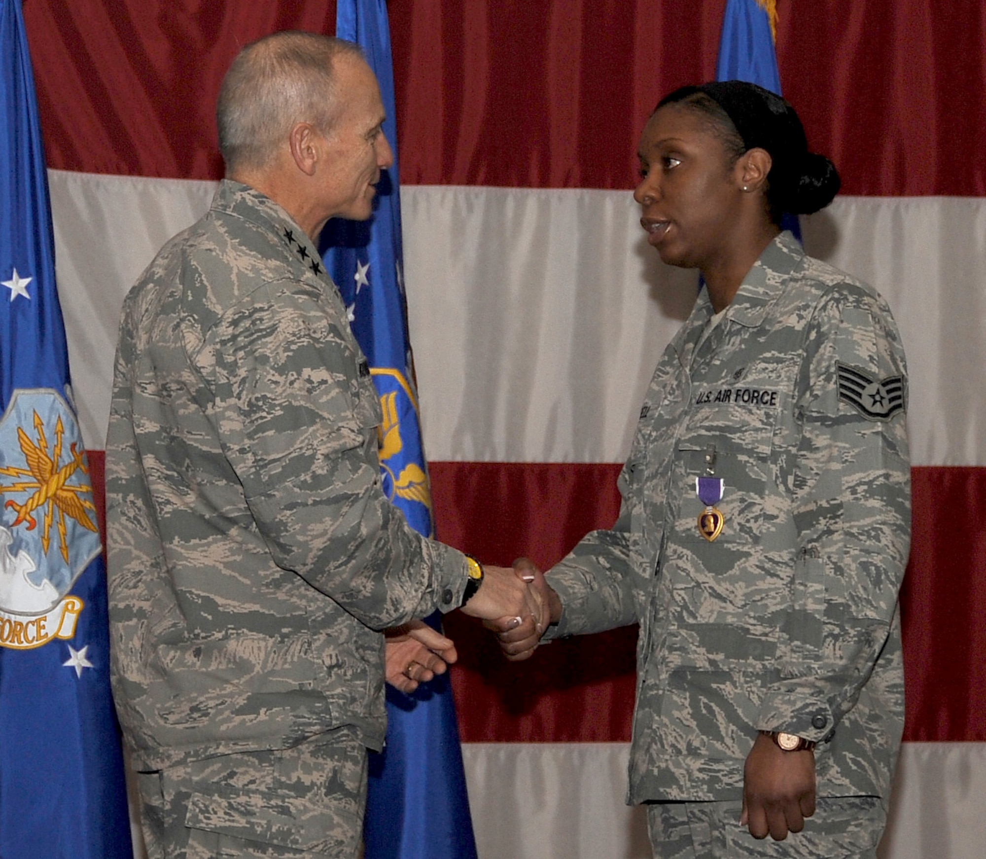 Lt. Gen. James Kowalski, Air Force Global Strike Command commander, shakes the hand of Staff Sgt. Jasmine Russell, 2nd Medical Operations Squadron, after presenting her with the Purple Heart during a ceremony at Hoban Hall on Barksdale Air Force Base, La., Feb. 7. Russell earned the Purple Heart after her deployment to Afghanistan in 2011 during Operation Enduring Freedom. After an improvised explosive device detonated under the vehicle she was traveling in, Russell aided members in her convoy even after sustaining injuries herself. (U.S. Air Force photo/Staff Sgt. Amber Ashcraft)