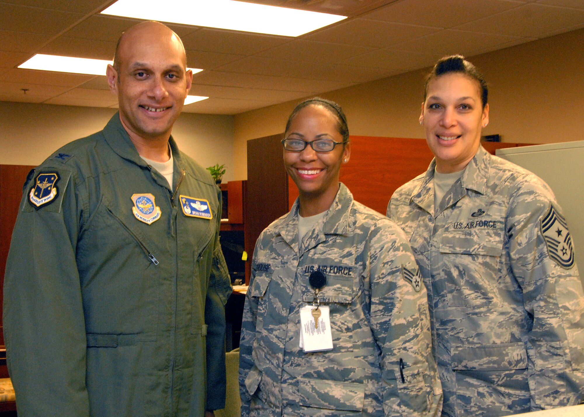 Col. Brian Robinson, 19th Airlift Wing commander, and Chief Master Sgt. Margarita Overton, 19th Airlift Wing command chief, congratulate Senior Airman Brittani Newhouse, 19th Medical Support Squadron uniform business office manager, for her selection as Combat Airlifter of the Week Jan. 30. Newhouse is the technical expert in medical billing for the 19th Medical Group. Her efforts recovered more than $1 million from 3rd party insurance companies. (U.S Air Force photo by Airman 1st Class Regina Agoha)  