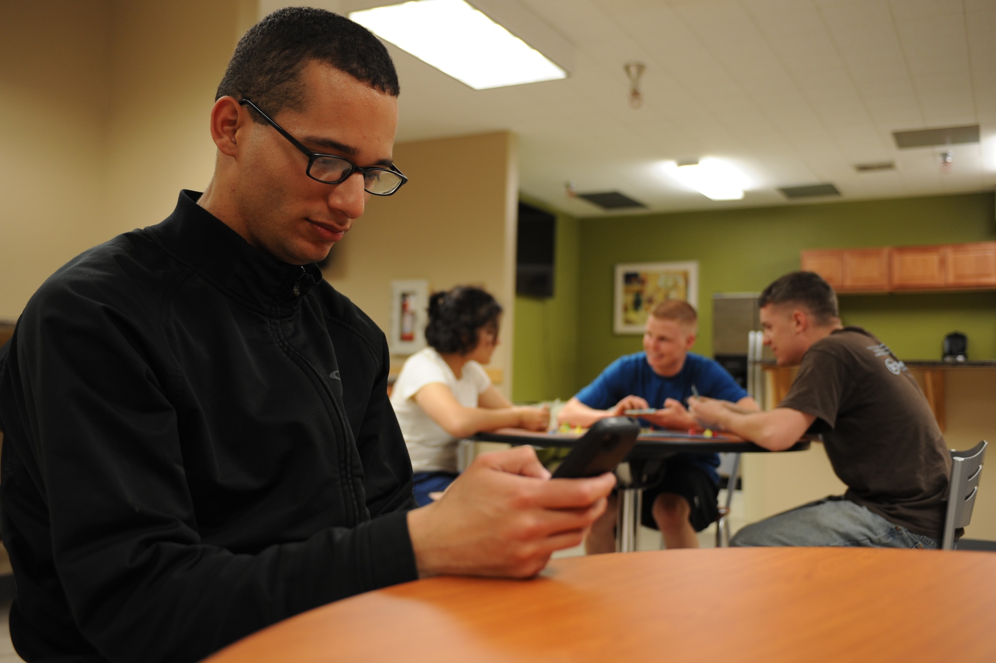 Nowadays, it is not uncommon to see people messaging on their cell phones while in social settings. This can often lead to a person becoming disconnected with those around him. So, put down the phone and pick up a conversation. (U.S. Air Force photo by Senior Airman Timothy Moore/Released)