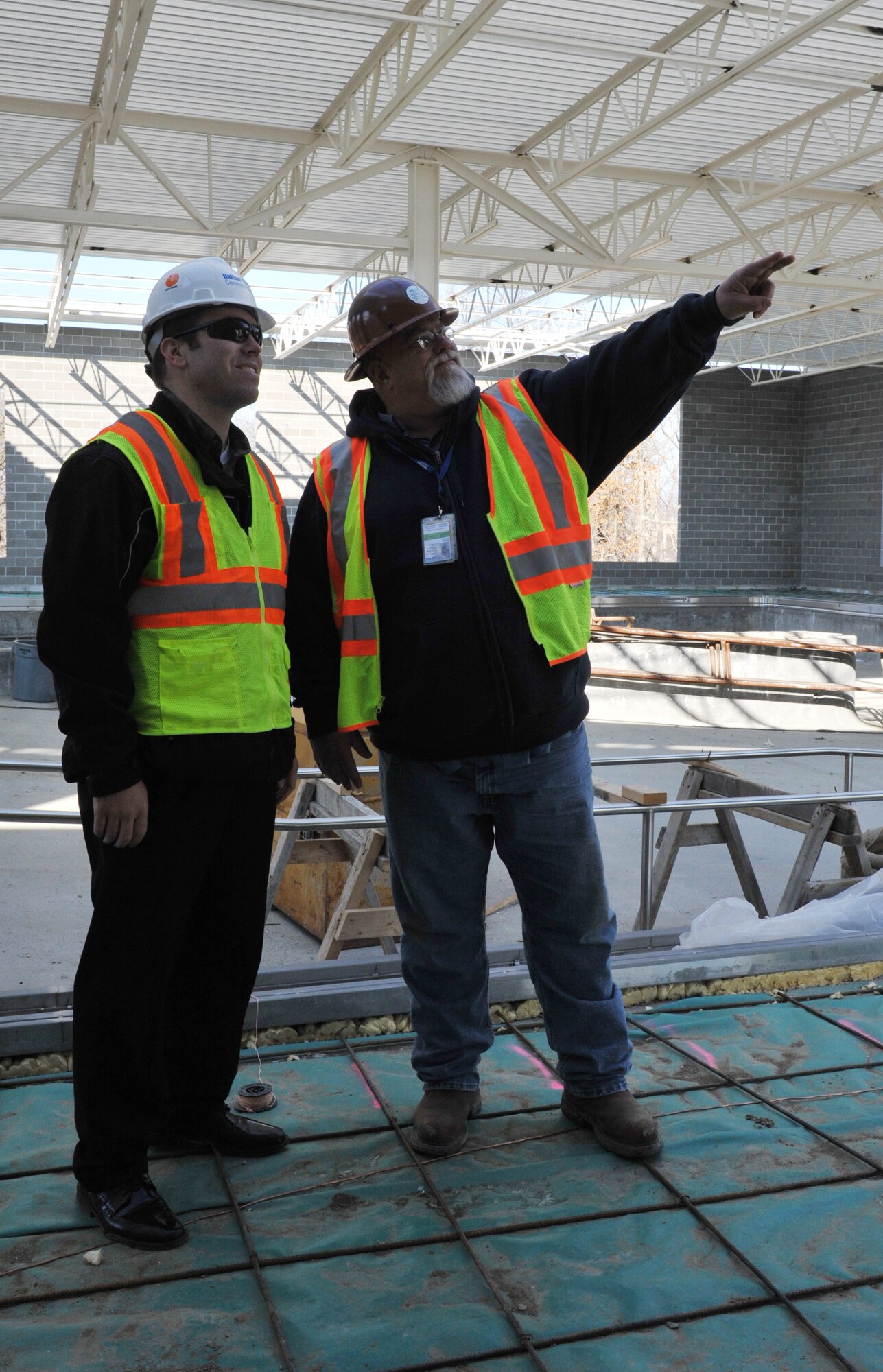 WHITEMAN AIR FORCE BASE, Mo. -- David Benson, Balfour Beatty Communities site superintendent, points out the progress made to Luke LaLiberty, BBC project director during a visit to the site, Jan. 22. The idea of the new fitness facility is to supplement existing activity fitness centers on base and encourage Team Whiteman to use them as well. (U.S. Air Force photo/Heidi Hunt)