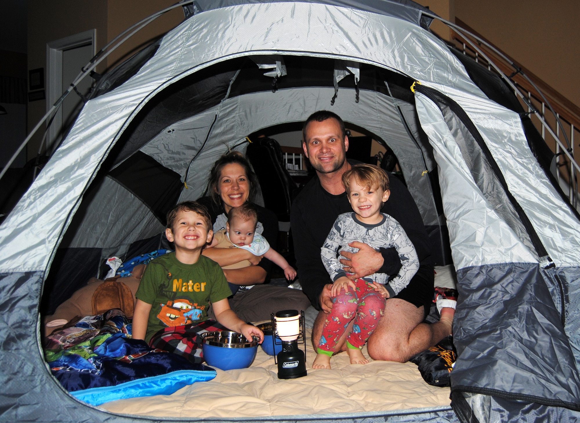 The Arnett family poses for a photo during an indoor camp-out in their home in Newport News, Va, in 2012. U.S. Army Capt. Arnett is currently deployed to Camp Buehring, Kuwait, and the family celebrates every day as a special adventure to help make the separation easier. (Courtesy photo/Released)