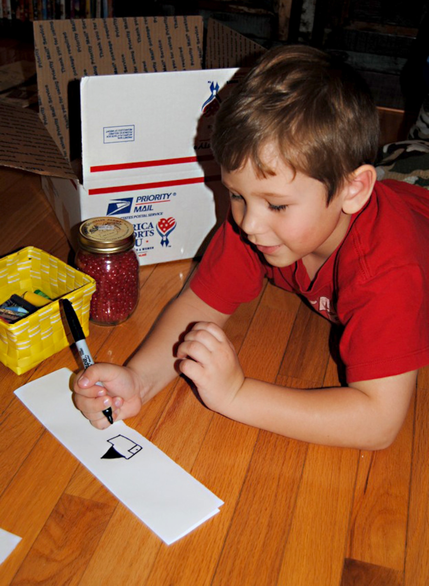Gammon Arnett draws a picture to put in a Valentine’s Day care package for his father, U.S. Army Capt. Sam Arnett, at his home in Newport News, Va., Feb. 2, 2013.  His father is currently deployed to Camp Buehring, Kuwait. (Courtesy photo/Released)