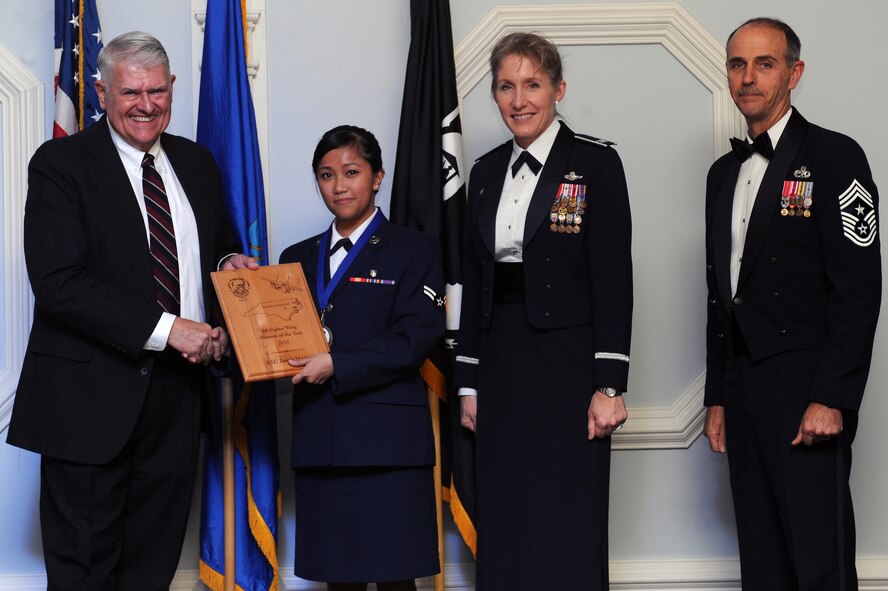 U.S. Air Force Airman 1st Class Janna Harina, 4th Medical Operations Squadron medical technician, receives the 4th Fighter Wing Airman of the Year award from retired Brig. Gen. Lawrence Huggins, during the annual awards banquet on Seymour Johnson Air Force Base, N.C., Feb. 2, 2013. (U.S. Air Force photo/Airman 1st Class John Nieves Camacho/Released)