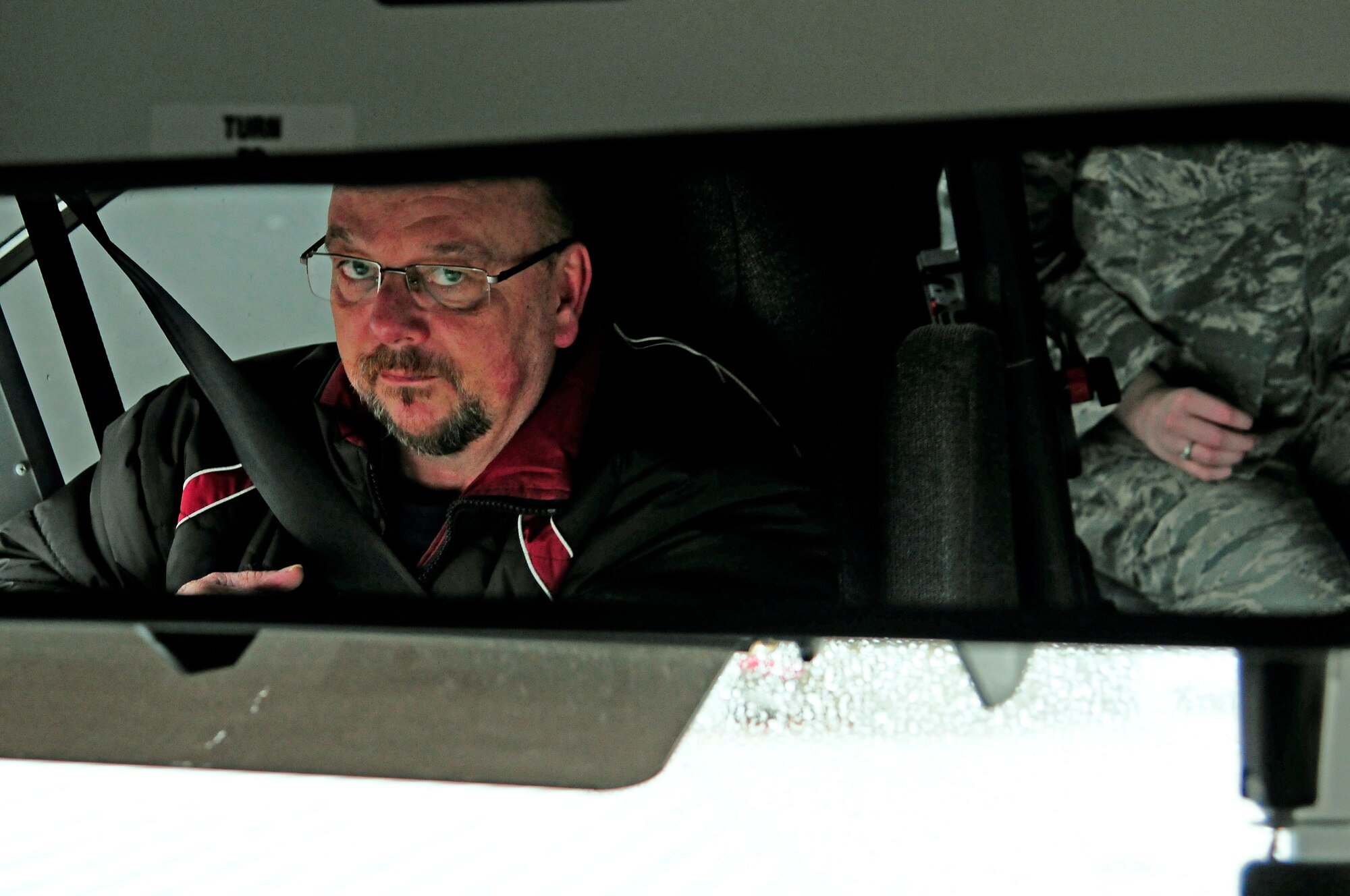 Ruegger Gerhard, 86th Vehicle Readiness Squadron bus driver, checks the rearview mirror to ensure safety while driving the base shuttle on Ramstein Air Base, Germany, Jan. 30, 2013. The base shuttle runs from 6 a.m. to 6 p.m. to allow Airmen and family members to get to appointments or across base during the day. (U.S. Air Force photo/Airman 1st Class Hailey Haux) 