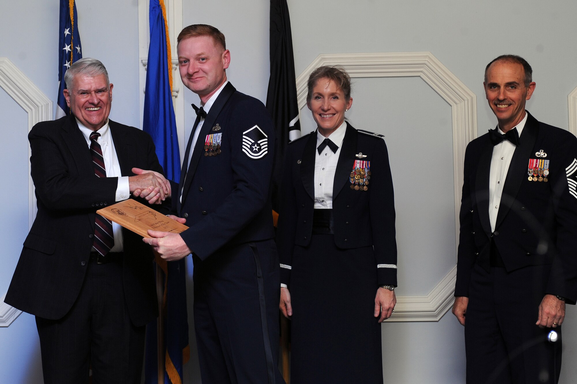 U.S. Air Force Master Sgt. Joel Desjardin, 4th Component Maintenance Squadron test measurement diagnostic equipment flight chief, accepts the 4th Fighter Wing Volunteer of the Year award from retired Brig. Gen. Lawrence Huggins, on behalf of Airman 1st Class Andrew Ayres, 4th CMS TMDE journeyman, during the annual awards banquet on Seymour Johnson Air Force Base, N.C., Feb. 2, 2013. (U.S. Air Force photo/Airman 1st Class John Nieves Camacho/Released)