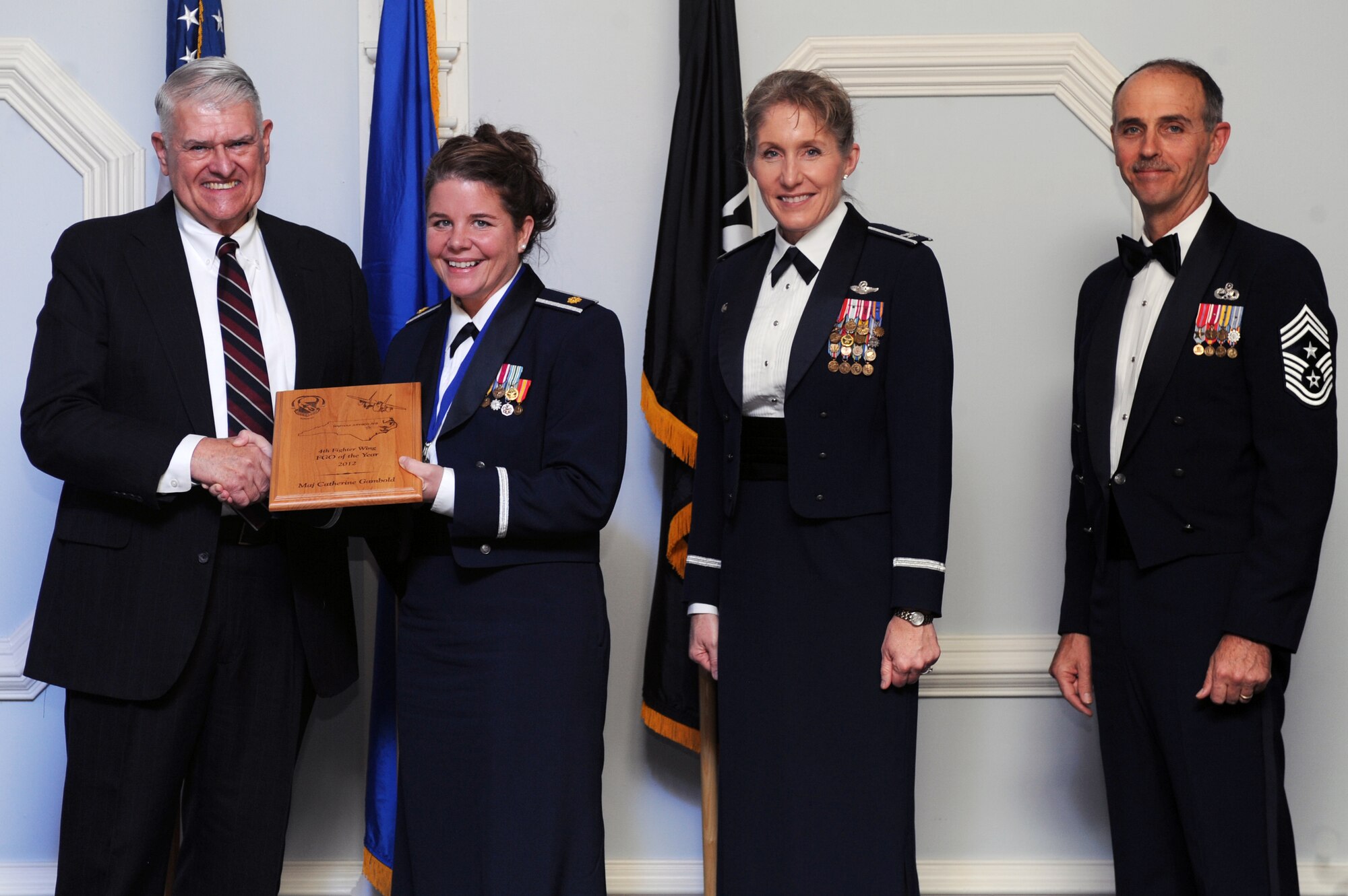 U.S. Air Force Maj. Catherine Gambold, 4th Operational Support Squadron chief of intelligence, receives the 4th Fighter Wing Field Grade Officer of the Year award from retired Brig. Gen. Lawrence Huggins, during the annual awards banquet on Seymour Johnson Air Force Base, N.C., Feb. 2, 2013. (U.S. Air Force photo/Airman 1st Class John Nieves Camacho/Released)