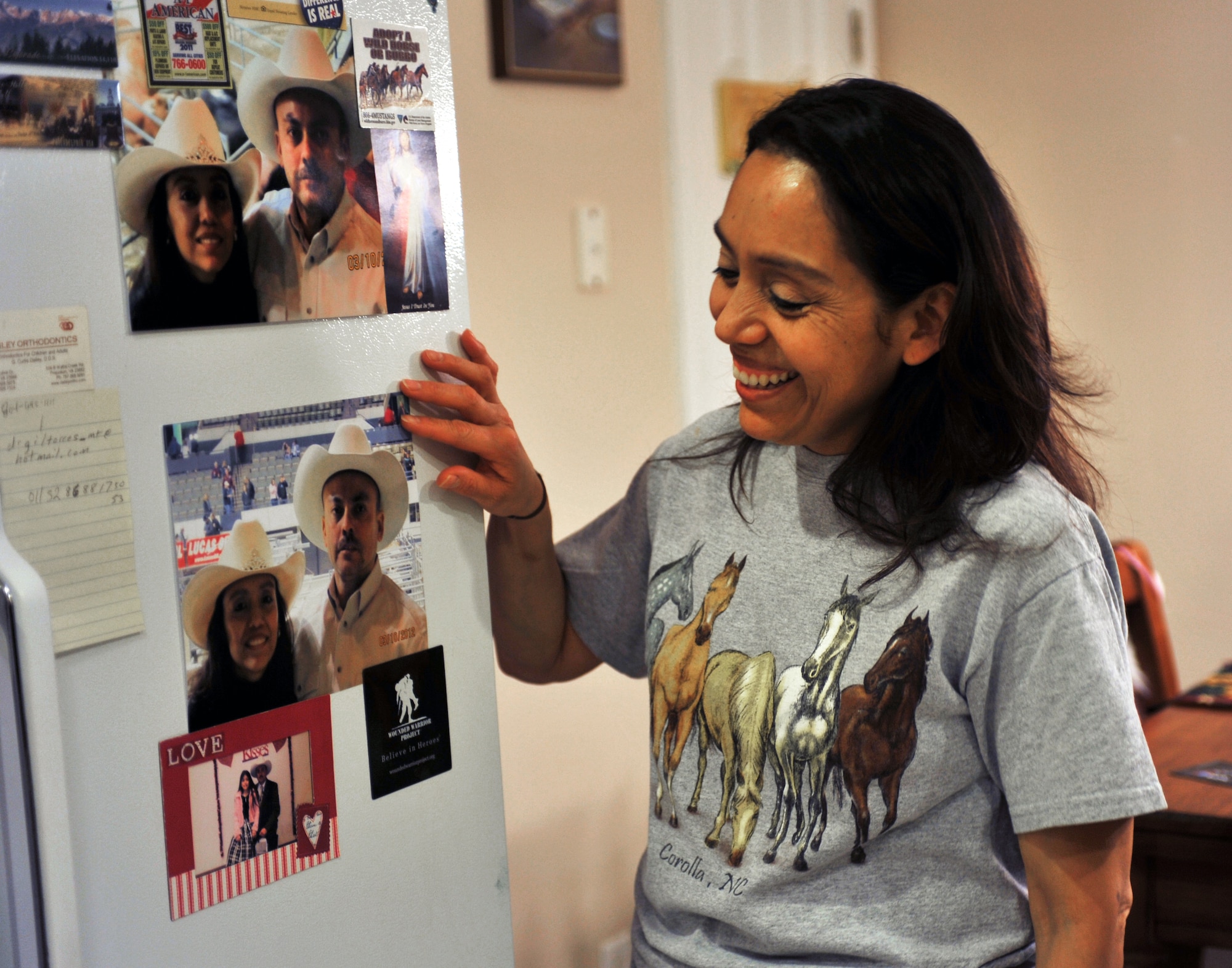 Beatriz Castillo, a software programmer at the NASA Langley Research Center in Hampton, Va., smiles as she looks at photos of her husband, Chief Master Sgt. Guillermo Castillo, Air Combat Command Inspector General superintendent of the maintenance division, at her home in Yorktown, Va, Jan. 30, 2013.  Mrs. Castillo's husband is currently deployed, and she says one of their favorite things to do together when he is home is to go to rodeos. (U.S. Air Force photo by Staff Sgt. Katie Gar Ward/Released)
