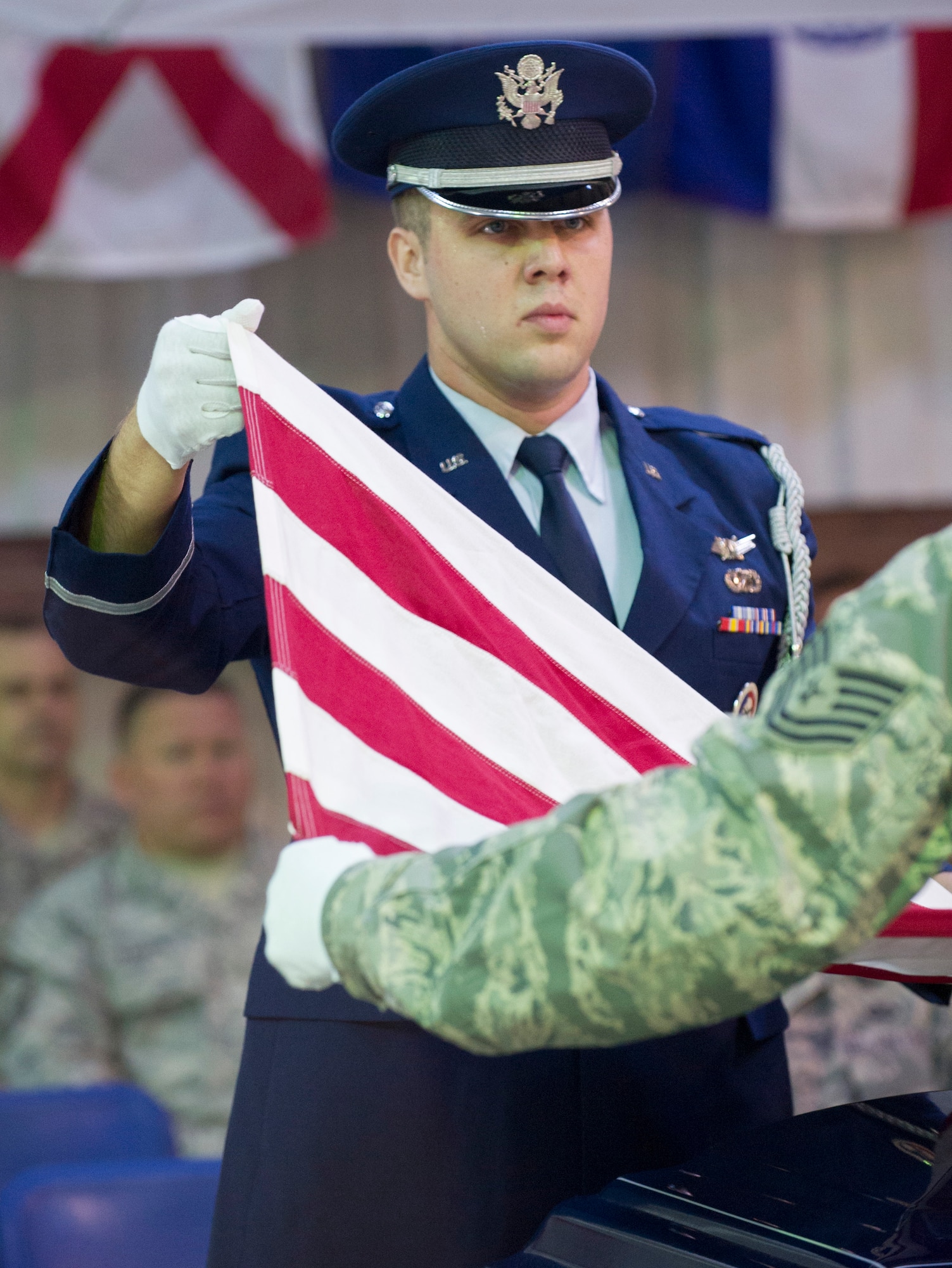 White Flight Honor Guard Company Grade Officer of the Year nominee, 1st Lt Gavin Brawley, 5 SLS, performs the six-person flag fold by calling non-verbal commands, popping the flag for every command during the Honor Guard Airman of the Year Board, which consisted of a total of 8 nominees competing in the Airmen, noncommissioned officer and Company Grade Officer categories. Participants had a uniform inspection, answered a series of questions and performed in a scenario unknown to them until the board presented it. (U.S. Air Force Photo/Matthew Jurgens.)