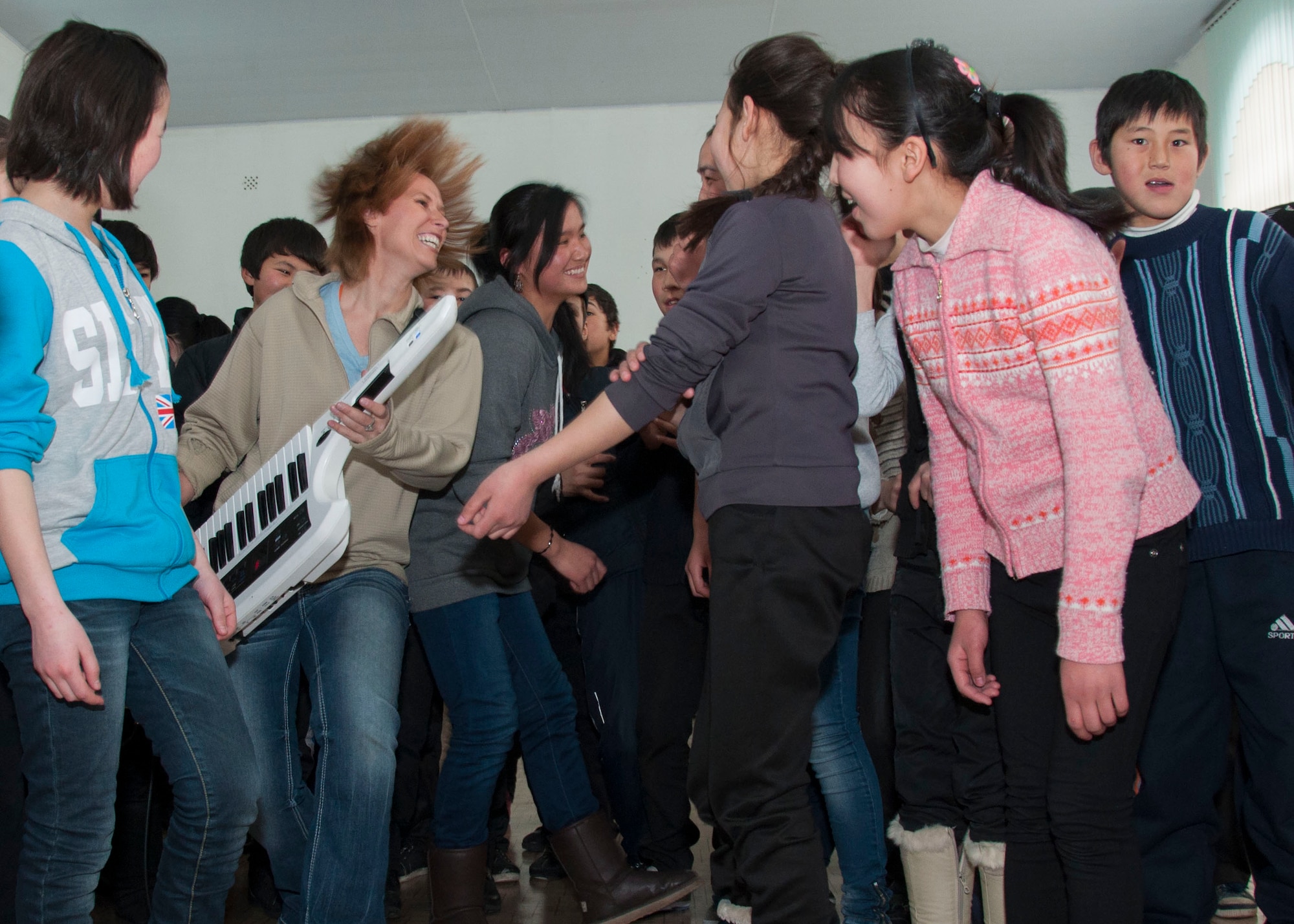 Senior Airman Michelle Hooper, U.S. Air Forces Central Command Band keyboard player, jams on the keytar to "Sweet Child of Mine" with students at the Chui Boarding School for Gifted Children in Tash Dobo Village Jan. 31, 2013. The AFCENT Band performed at five different schools during their two-week tour of Kyrgyzstan. (U.S. Air Force photo/Tech. Sgt. Rachel Martinez)