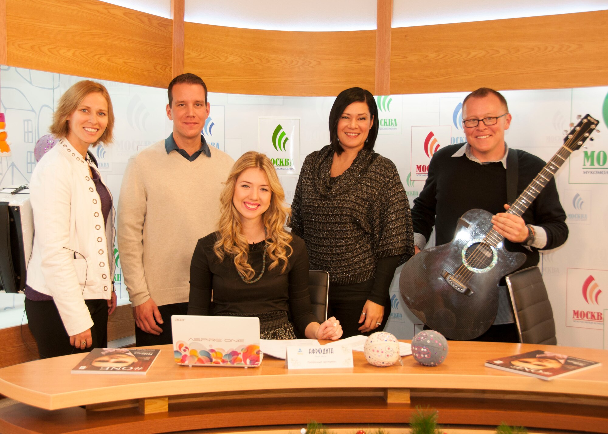 Standing from left to right, Senior Airman Michelle Hooper, Staff Sgt. Andy Wendzikowski, Tech. Sgt. Frances Kness and Staff Sgt. Josh Byrd, members of the U.S. Air Forces Central Command Band 'Total Force,' pose for a photo with Ksenia Barannikova, host of Good Morning TV, at the NTS network studio in Bishkek, Jan. 28, 2013. The band was interviewed and played a live song for the Kyrgyz television audience. (U.S. Air Force photo/Tech. Sgt. Rachel Martinez)