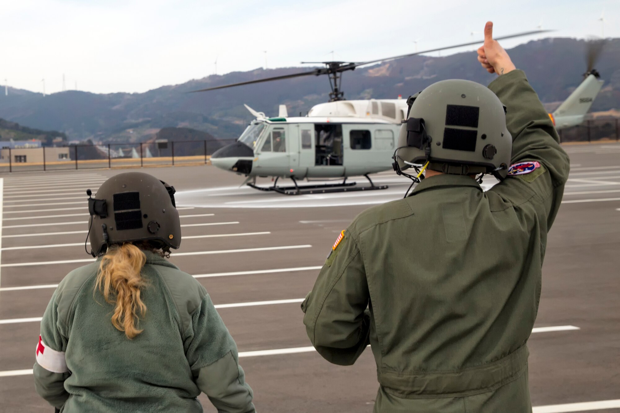 SHIZUOKA PREFECUTERE, Japan -- U.S. Air Force Staff Sgt. Arturo Fernandez, right, 459th Airlift Squadron flight engineer, thumbs-up after completing an emergency landing drill to the UH-1N Huey pilots at Shin-Tomei expressway's service area, Shizuoka Prefecture, Feb. 5, 2013. (U.S. Air Force photo by Osakabe Yasuo)