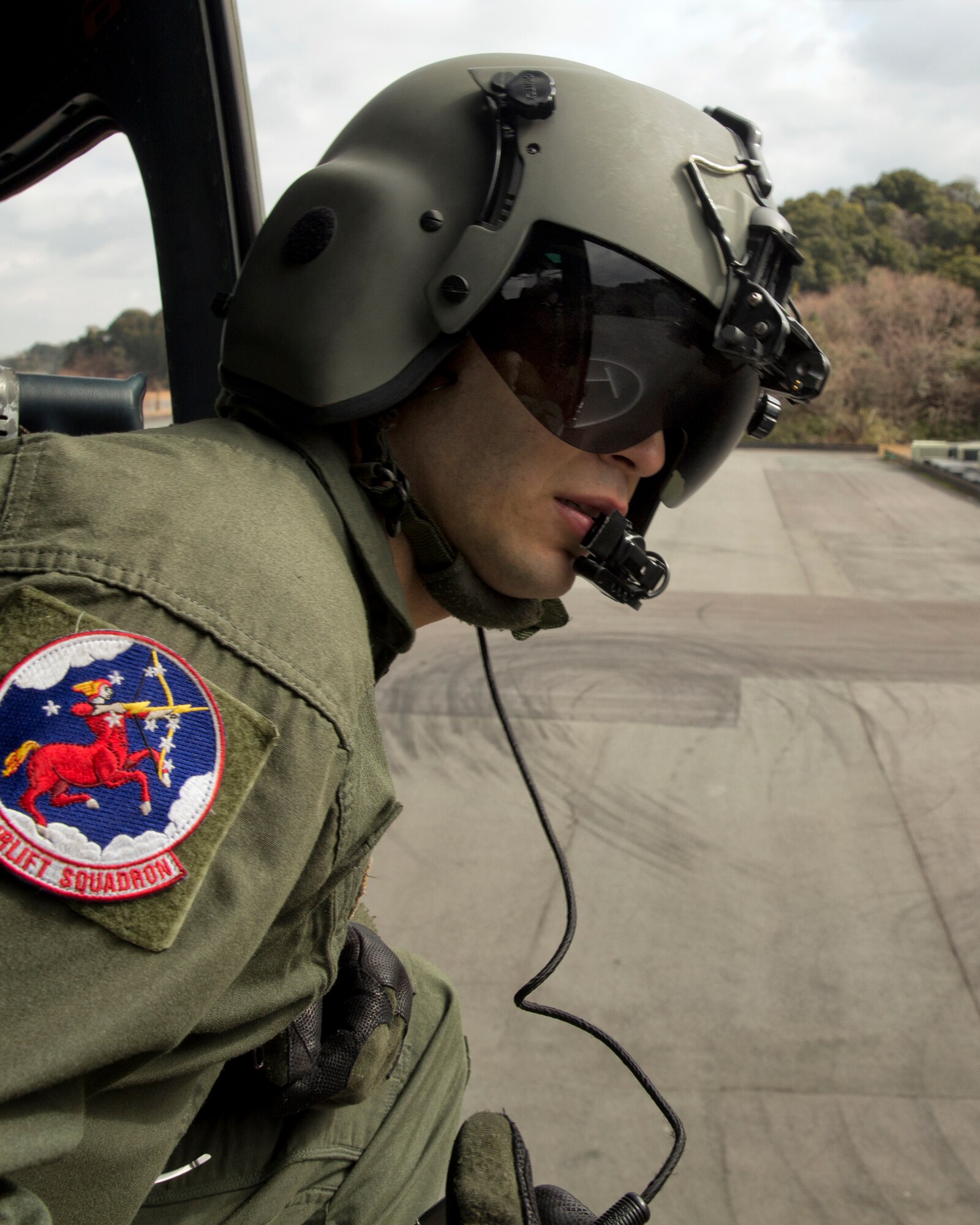 SHIZUOKA PREFECTURE, Japan -- Staff Sgt. Arturo Fernandez, 459th Airlift Squadron flight engineer, looks out the open door of a UH-1N Huey before landing at the Ogasa-Yama park by the Shin-Tomei expressway in the Shizuoka prefecture, Japan, Feb. 5, 2013. The Shizuoka Prefectural Government hosted the drill, which required the practice of using expressway's service area as an emergency landing zone for helicopters. (U.S. Air Force photo by Osakabe Yasuo)