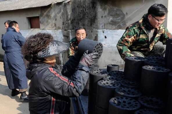 Republic of Korea air force personnel and volunteers from Jeou Ju Yanttan Bank deliver coal to a residence in Gunsan City, Republic of Korea, Jan 30, 2013. This program has been going on for five years through the Gunsan City Hall to ensure needy families stay warm, and this year the 38th Fighter Group invited the Wolf Pack to participate. (U.S. Air Force photo by Senior Airman Marcus Morris/Released)