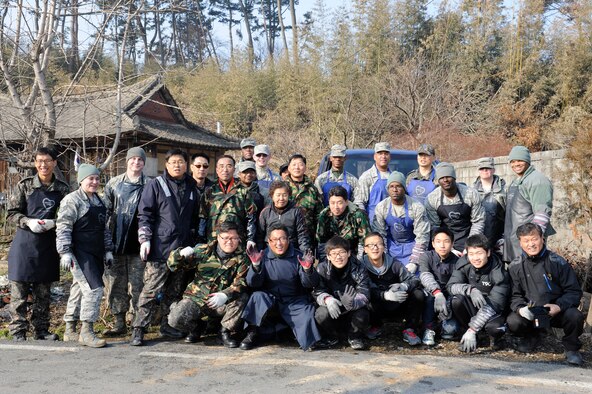 U.S. and Republic of Korea air force personnel and volunteers from Jeou Ju Yanttan Bank pose for a photo after delivering coal to a residence in Gunsan City, Republic of Korea, Jan 30, 2013. This program has been going on for five years through the Gunsan City Hall to ensure needy families stay warm, and this year the 38th Fighter Group invited the Wolf Pack to participate. (U.S. Air Force photo by Senior Airman Marcus Morris/Released)