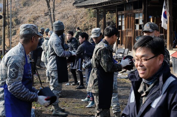 U.S. and Republic of Korea air force personnel move coal briquettes into a resident’s home at Gunsan City, Republic of Korea, Jan. 30, 2013. More than 7,700 pounds of coal were donated to needy families to heat their homes, and the Wolf Pack helped deliver it. (U.S. Air Force photo by Senior Airman Marcus Morris/Released)