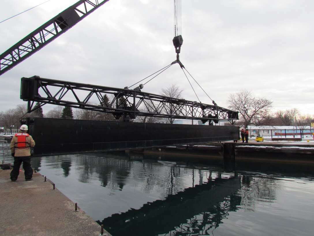 A stop log spans the upper end of the MacArthur Lock before being dropped into the slots built into the wall.  Once all the logs are set and the leaks plugged the lock can be dewatered.